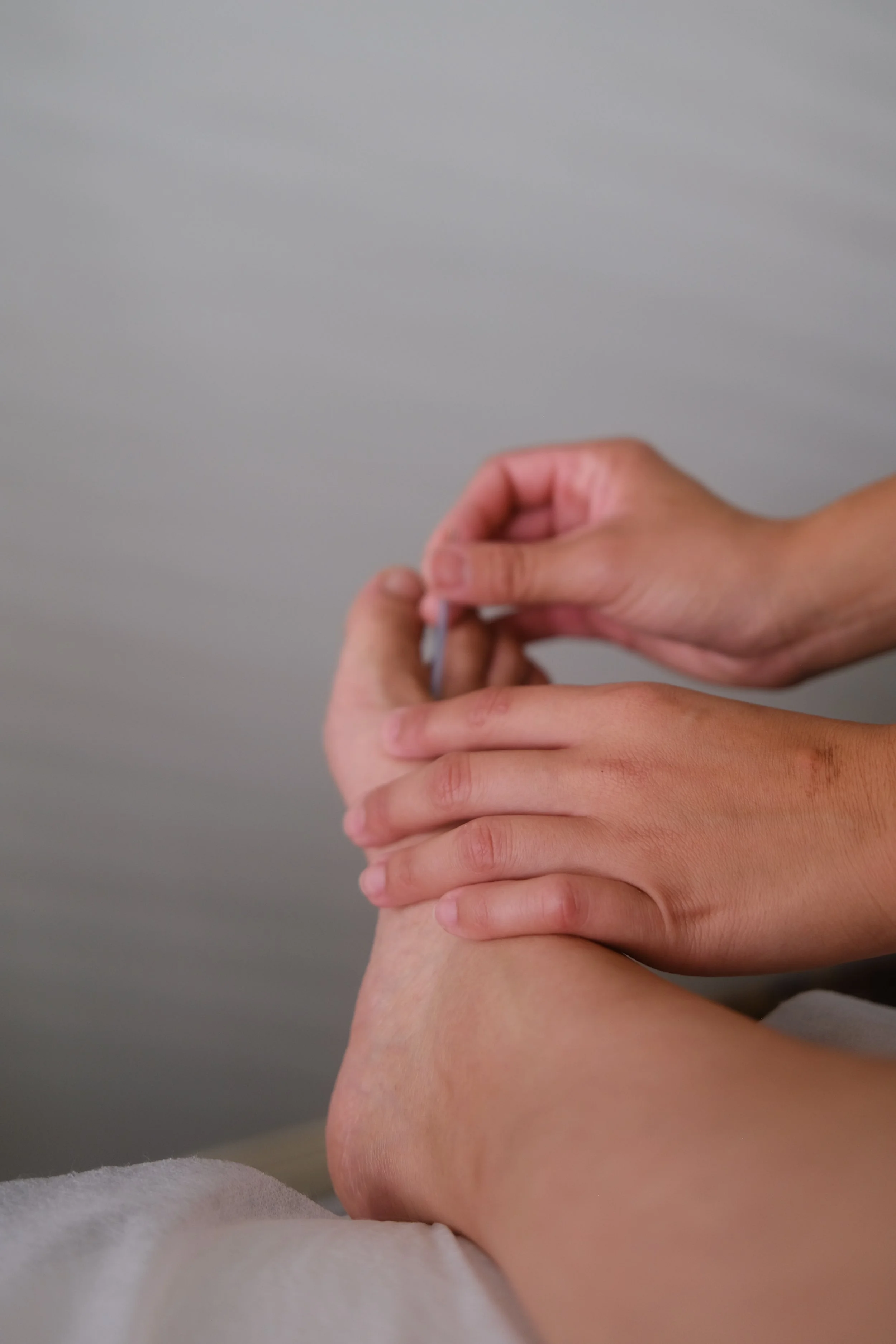 A person receiving cupping therapy on their back using glass cups and a vacuum device.