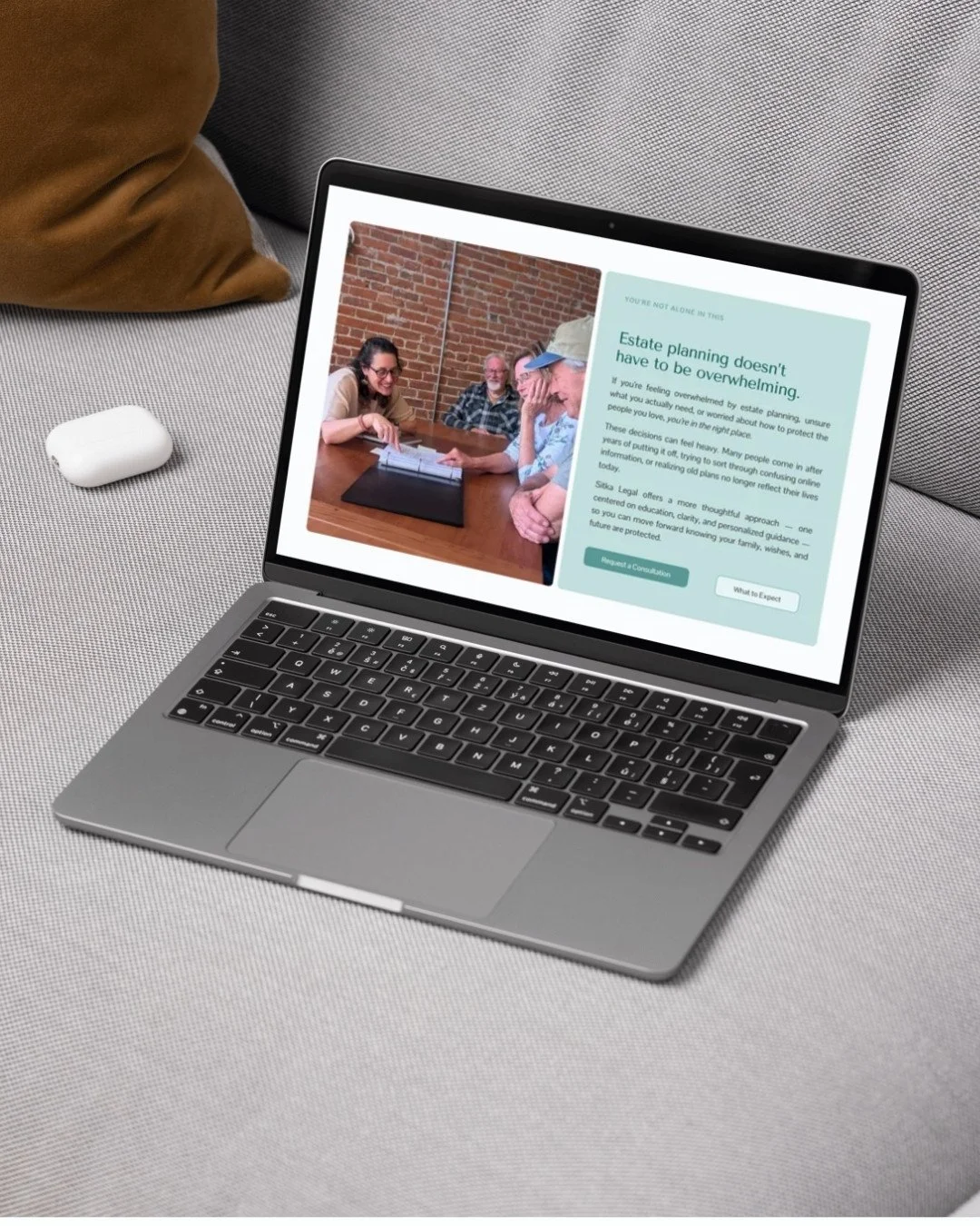 Open laptop on a light gray surface showing a website about estate planning, with a photo of four people sitting at a table and chatting.