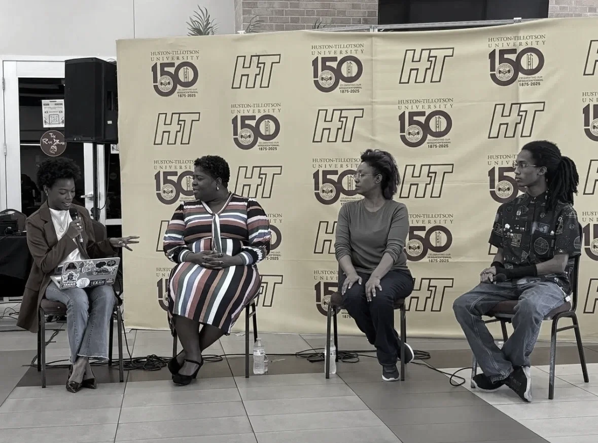 Four women sitting on chairs in front of a backdrop with Hamilton-Tillotson University 150th anniversary logo. One woman on the far left is speaking into a microphone, while the others are listening. There is a water bottle on the floor between two of the women.