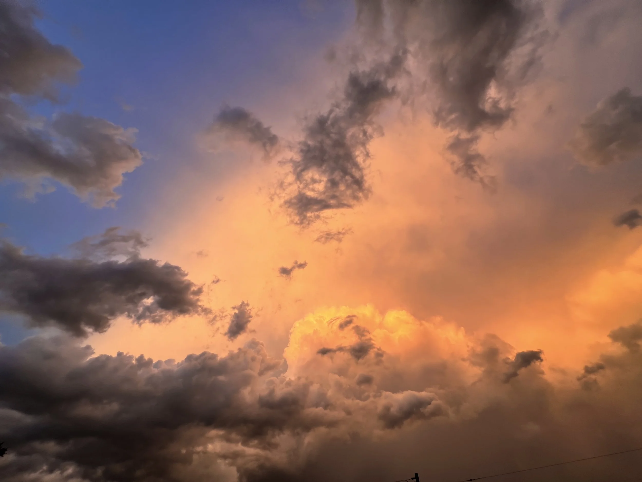 Colorful sky with dark and light clouds during sunset or sunrise.