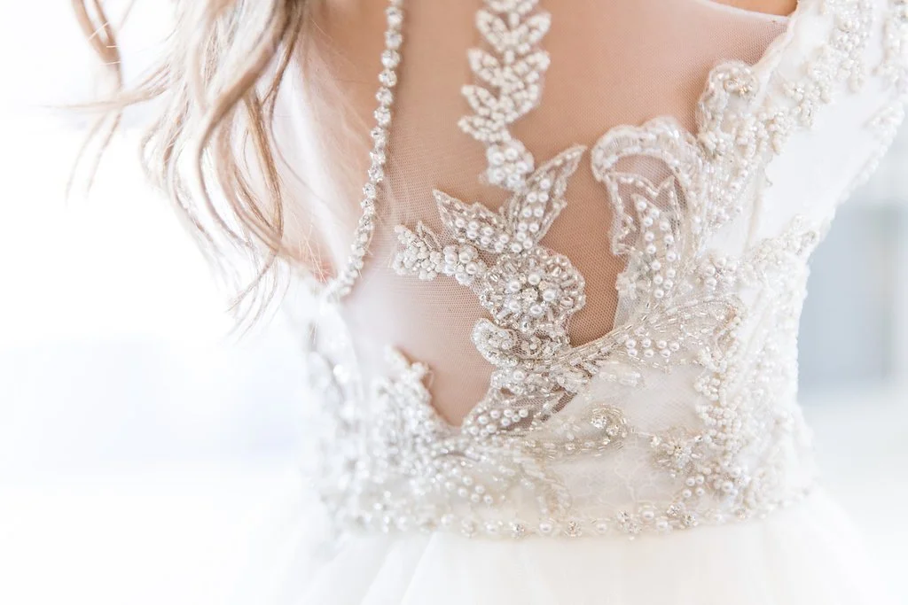 Close-up of a wedding dress with intricate lace and beadwork on the bodice.