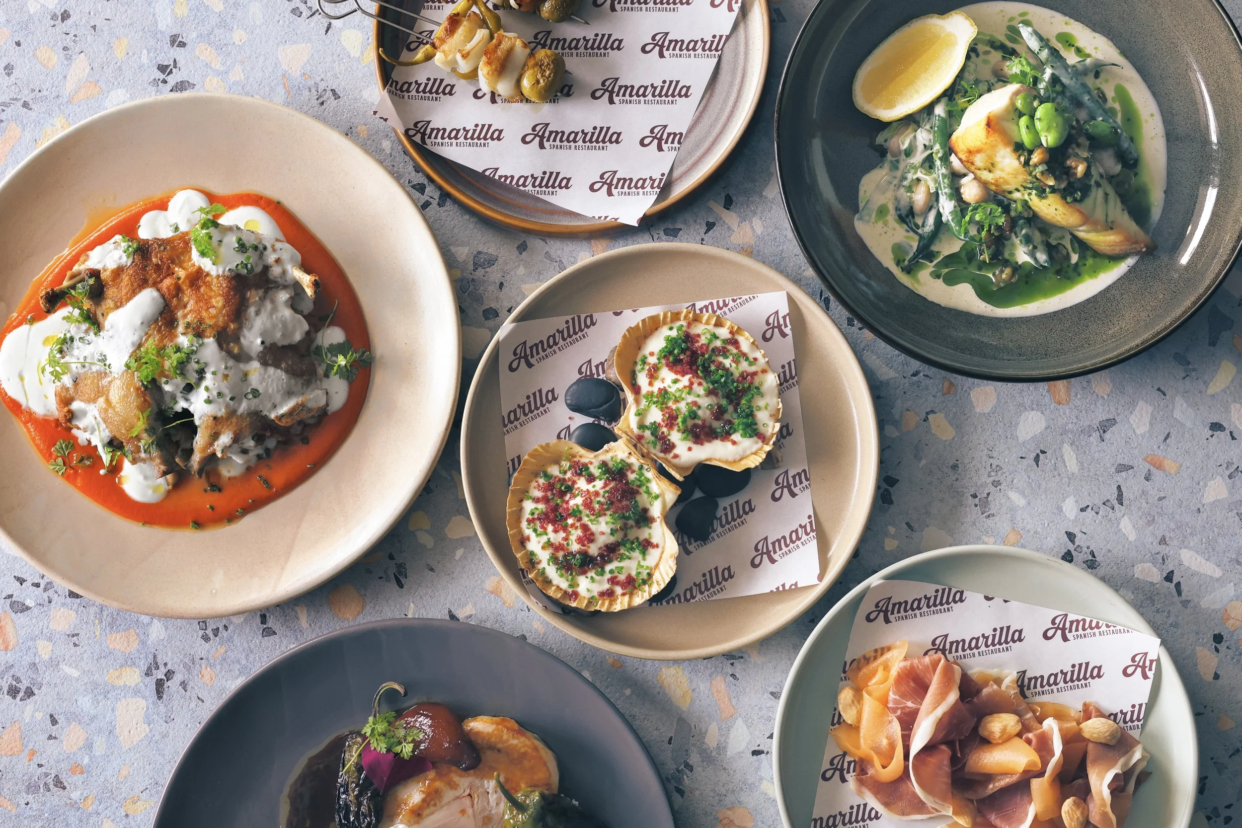 various spanish tapas style food dishes plated on table at Amarilla Restaurant terrigal