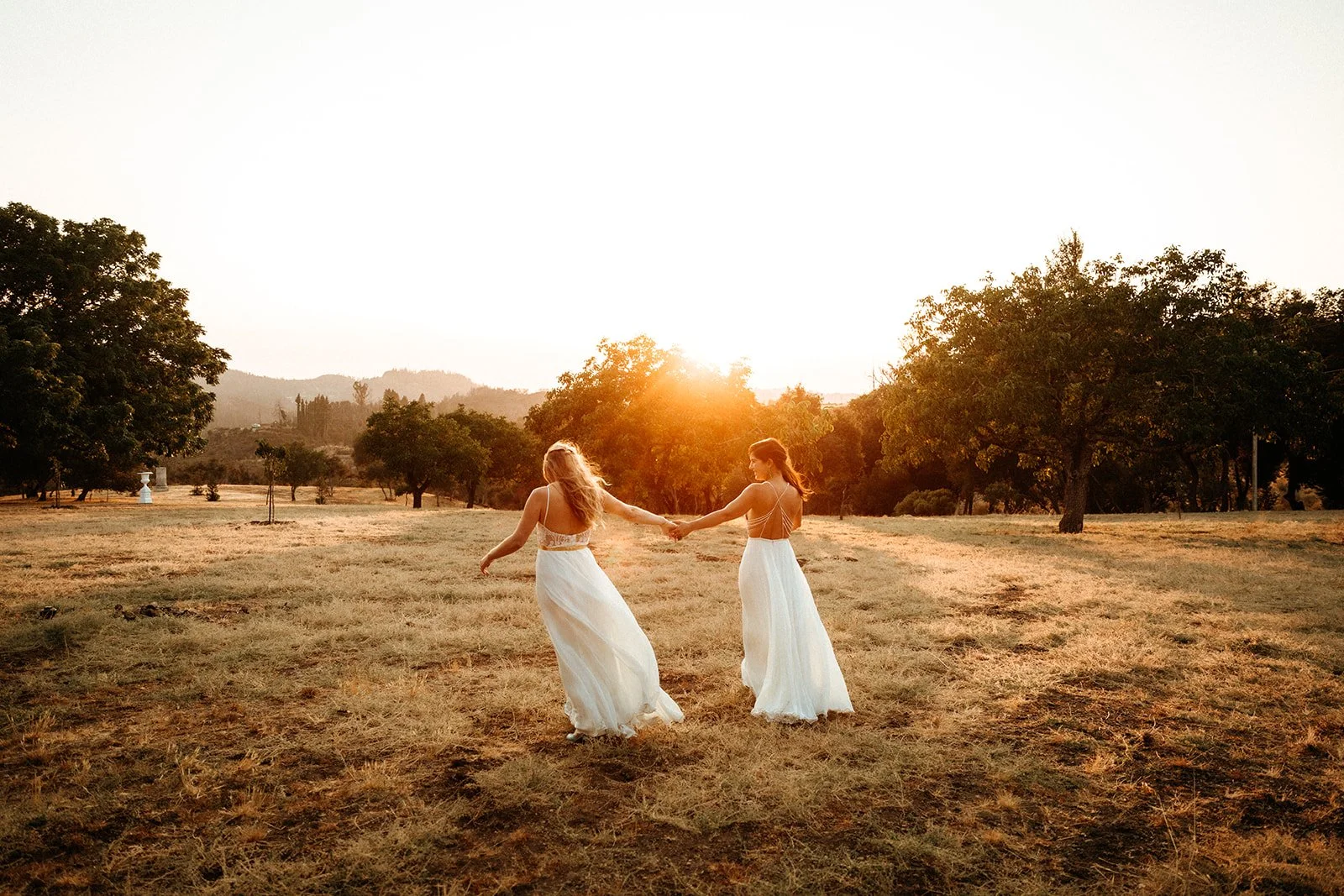 Two brides walking together at at Laura + Abbey's wedding at Triple S Ranch, in Calistoga, California
