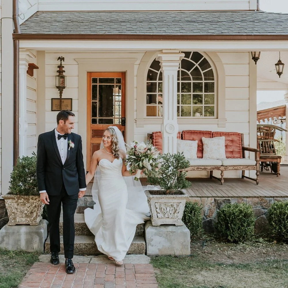 Bride and groom walking hand in hand outside house on wedding day, smiling at each other at Triple S Ranch wedding venue in Napa California