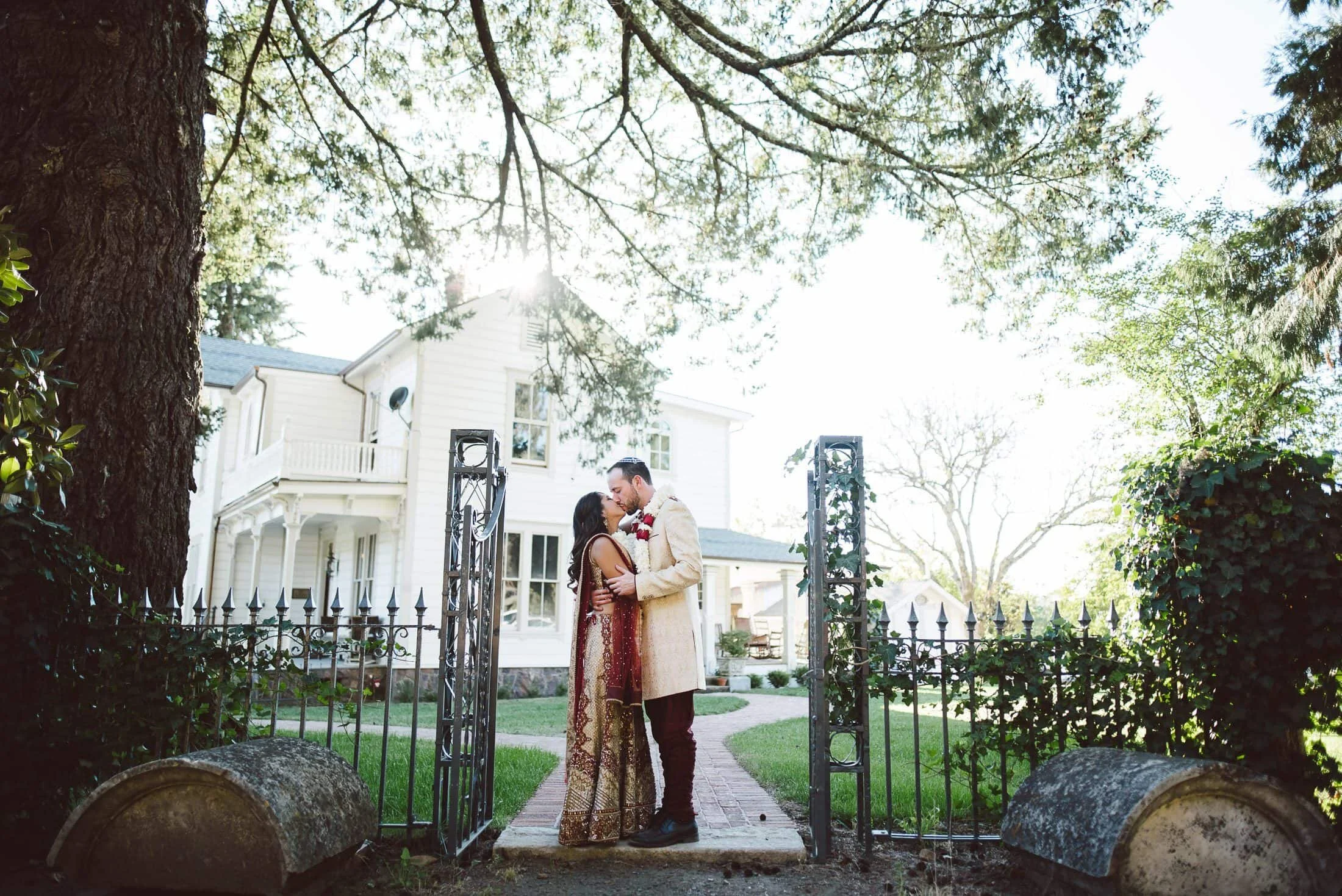 Bride and groom kissing by iron fence at Triple S Ranch, in Calistoga, California