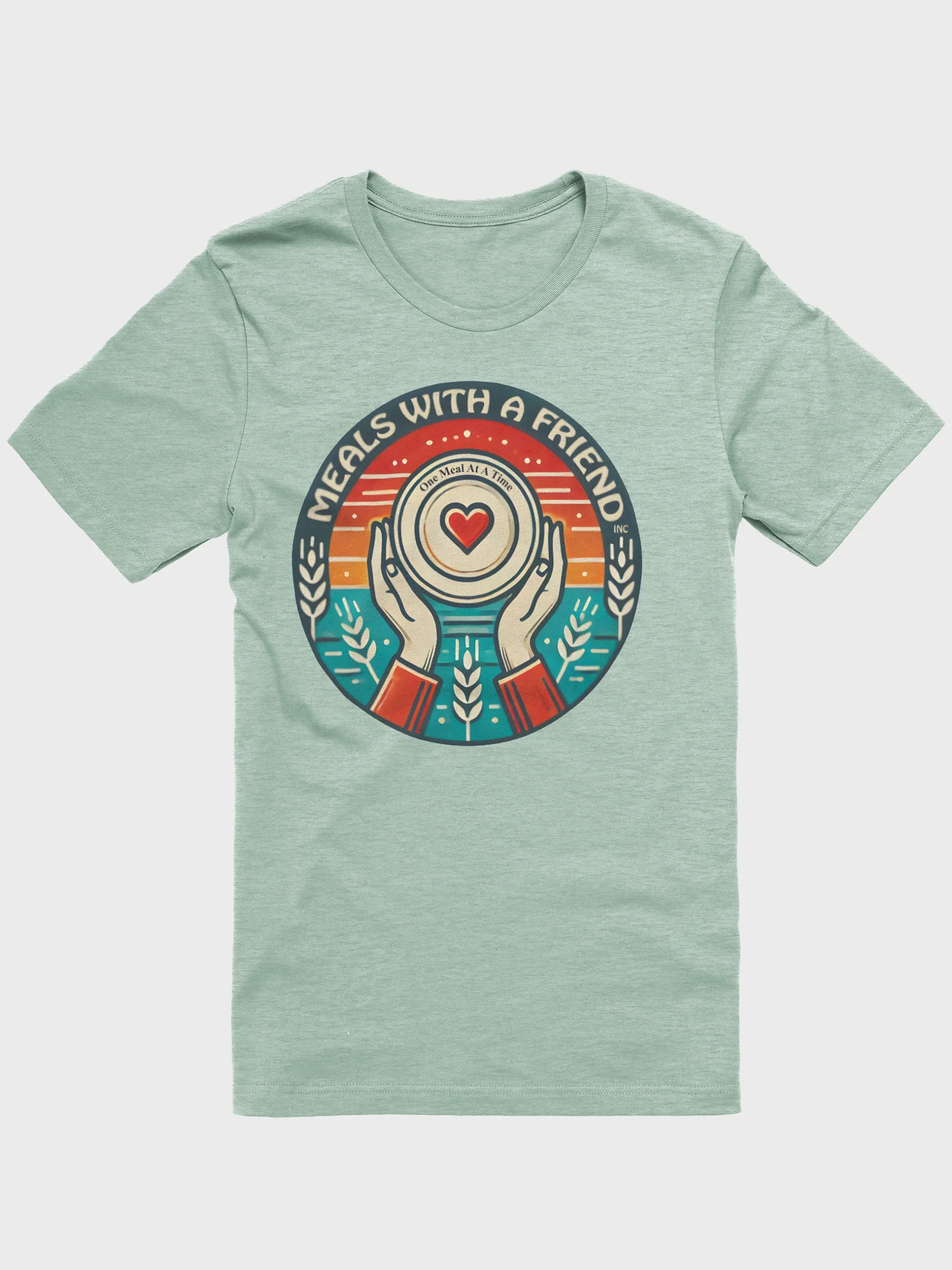 Light green T-shirt with graphic showing two hands holding a plate with a heart and the text "Meals with a Friend" and "One Meal At A Time".