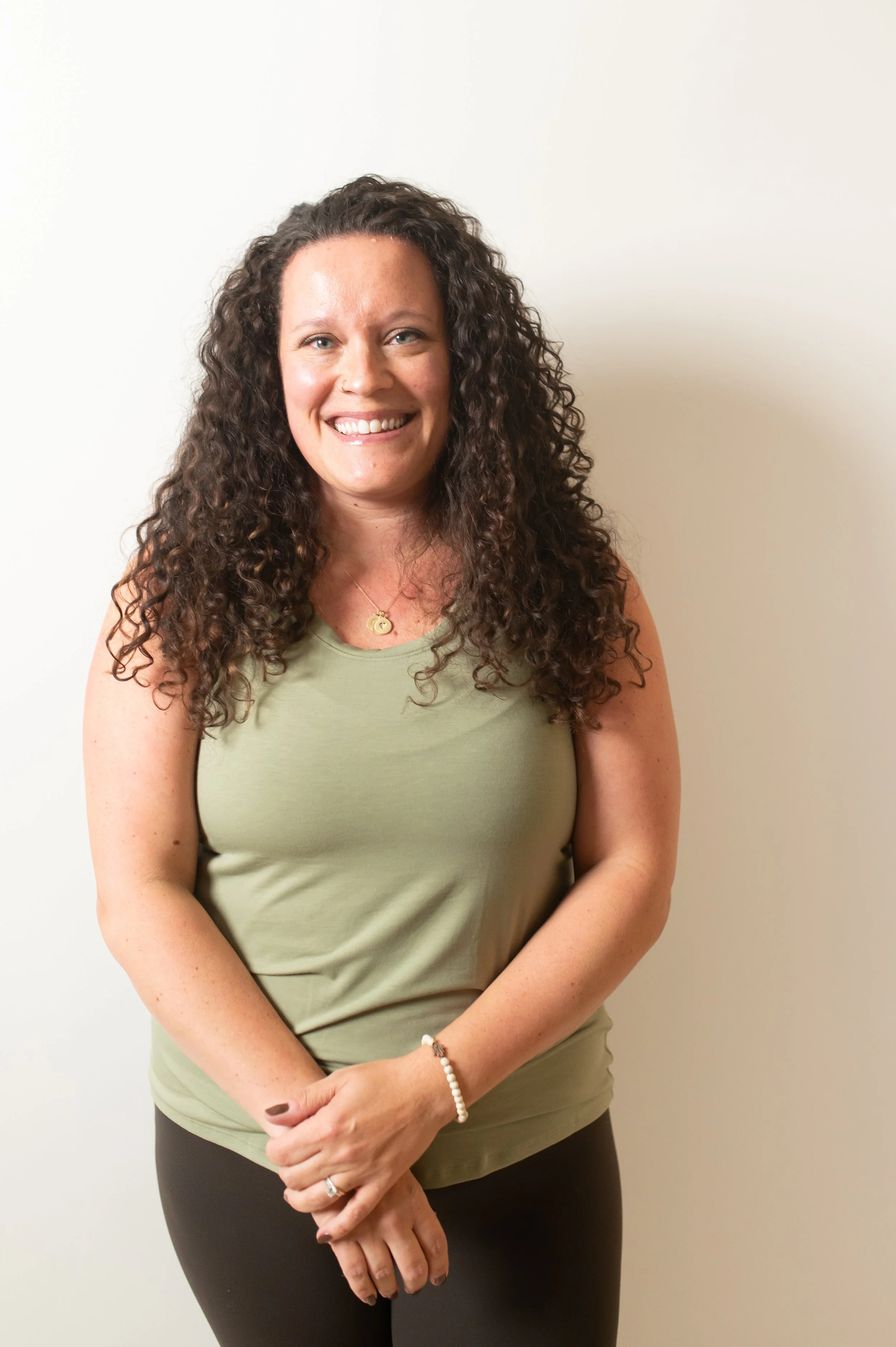 Text reading 'the wild OM' in orange serif font over a light background with faint shadows of leaves or foliage.