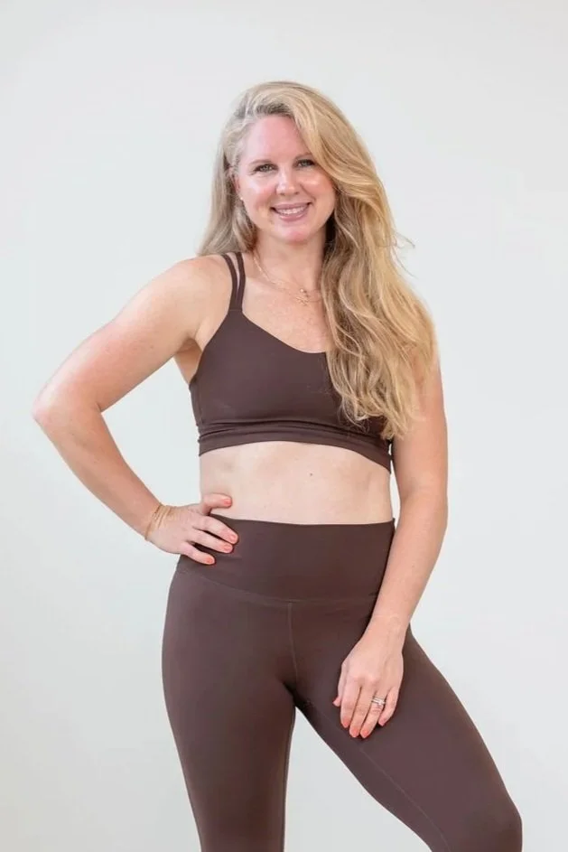 A woman sculpting indoors, standing strong with curly blond hair