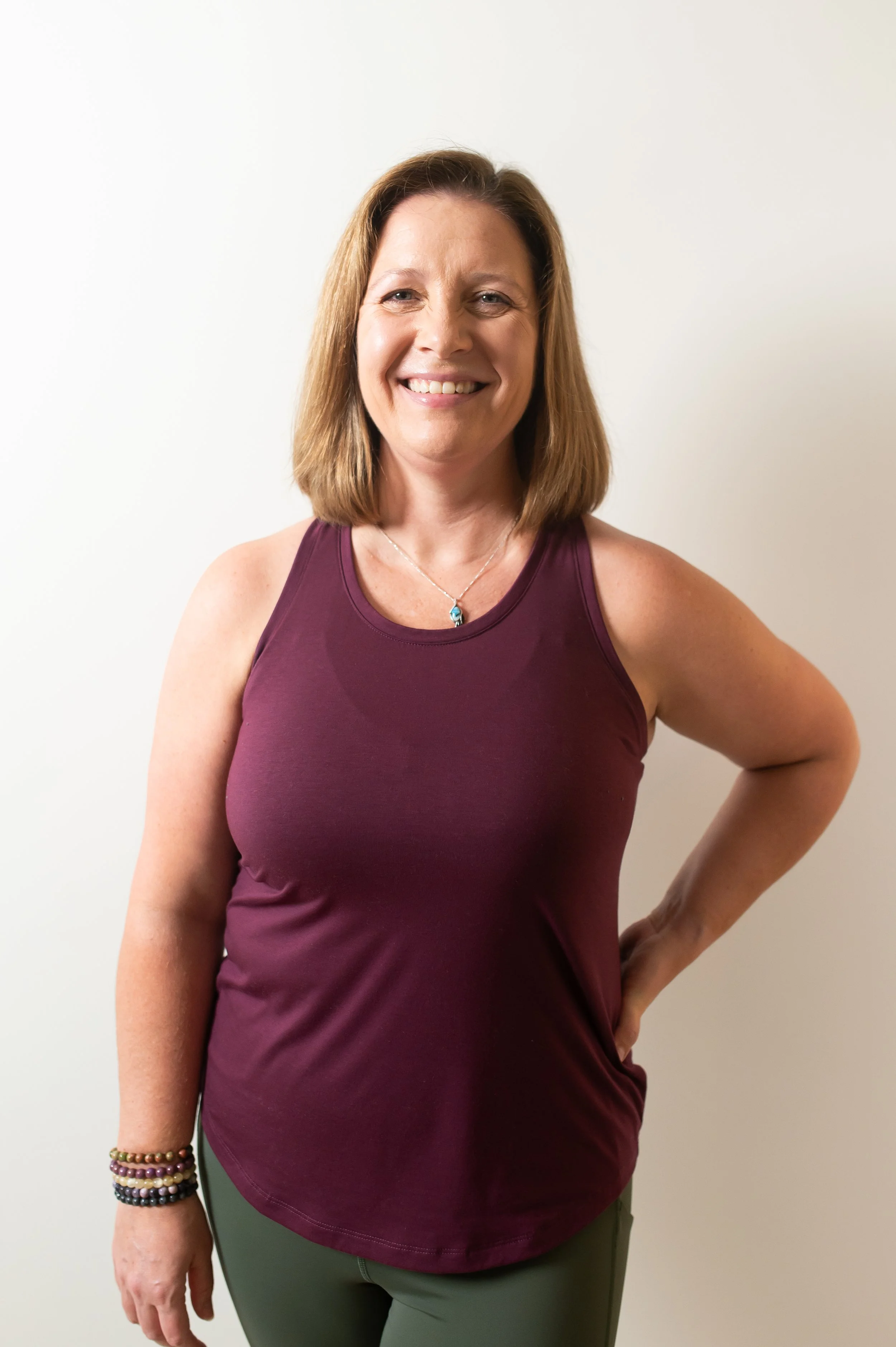 The cover of a book titled 'The Wild OM' with a soft white background and faint shadow of a fern leaf.