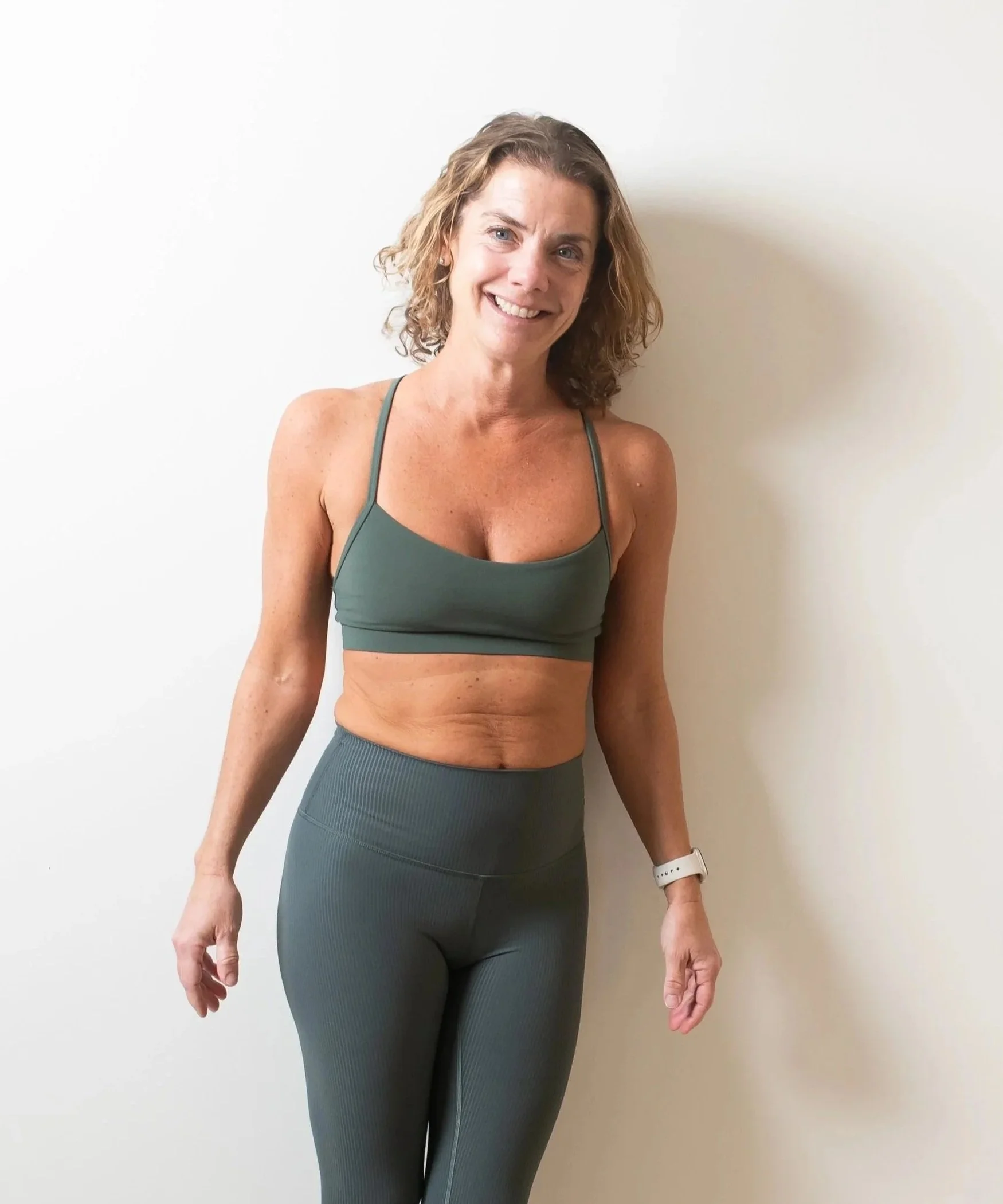 A soft, blurry image of fern leaves with the words 'the wild OM' written in elegant, reddish-brown font over the center.