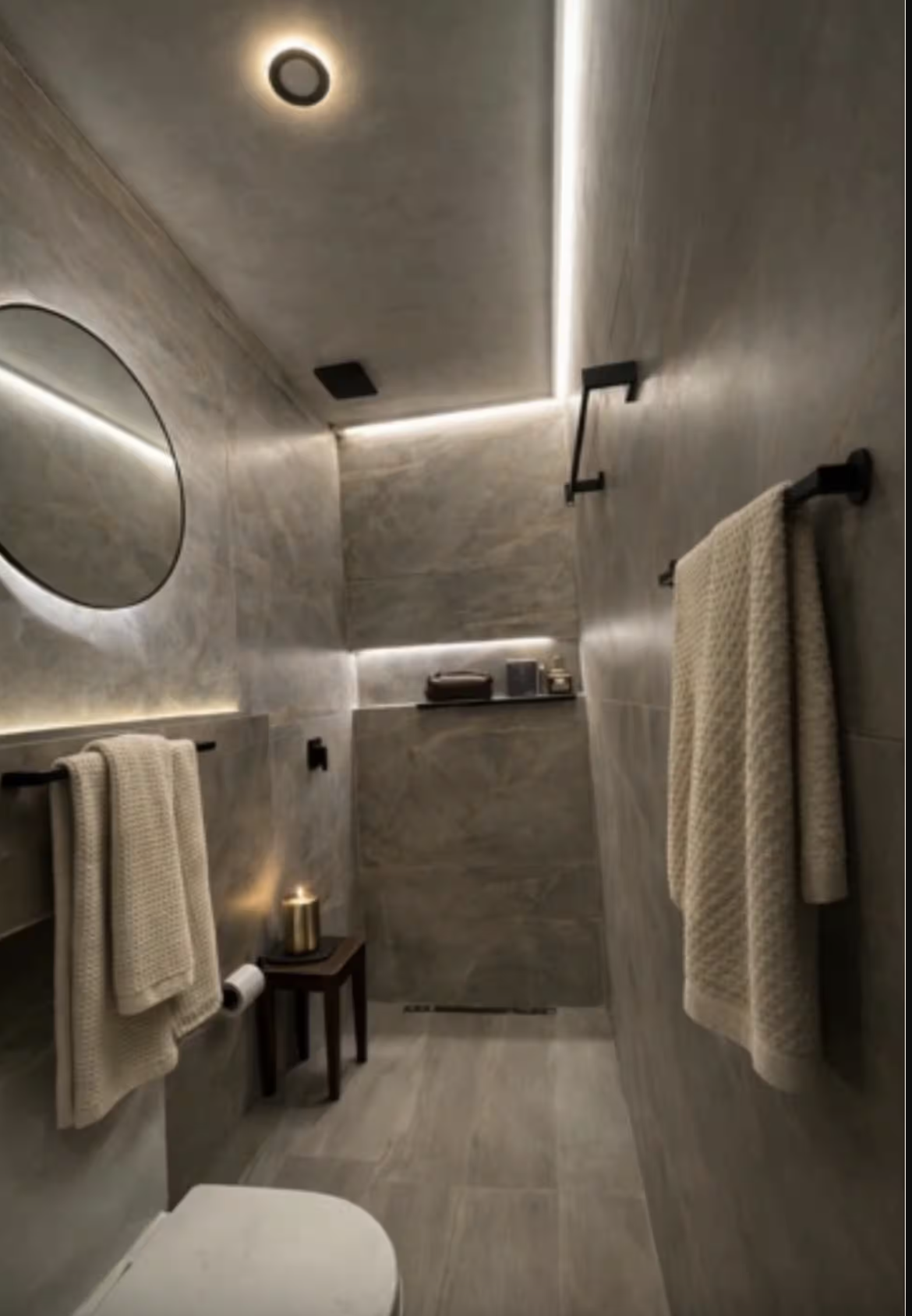 Modern bedroom with a king-sized bed, white bedding, blue accent pillows, wooden beams on the ceiling, flat-screen TV, and wooden door.