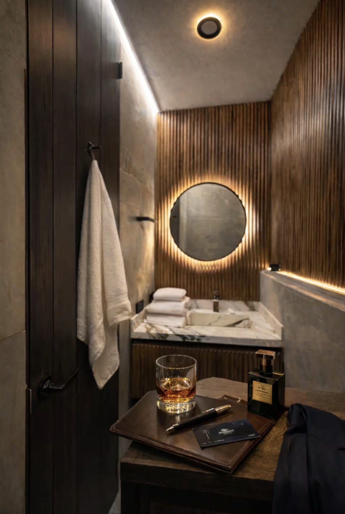 Luxurious bedroom with wooden ceiling beams, modern fireplace, wall-mounted TV, large bed with decorative pillows, and a glass door leading to a garden view.