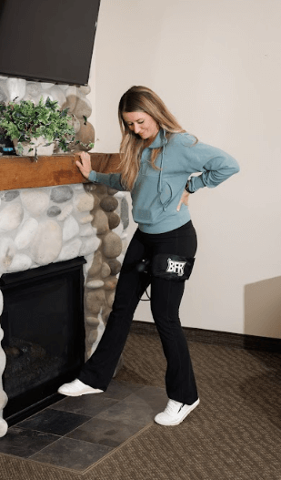person holding on to a fireplace mantle wearing The BFR Cuff on her left leg