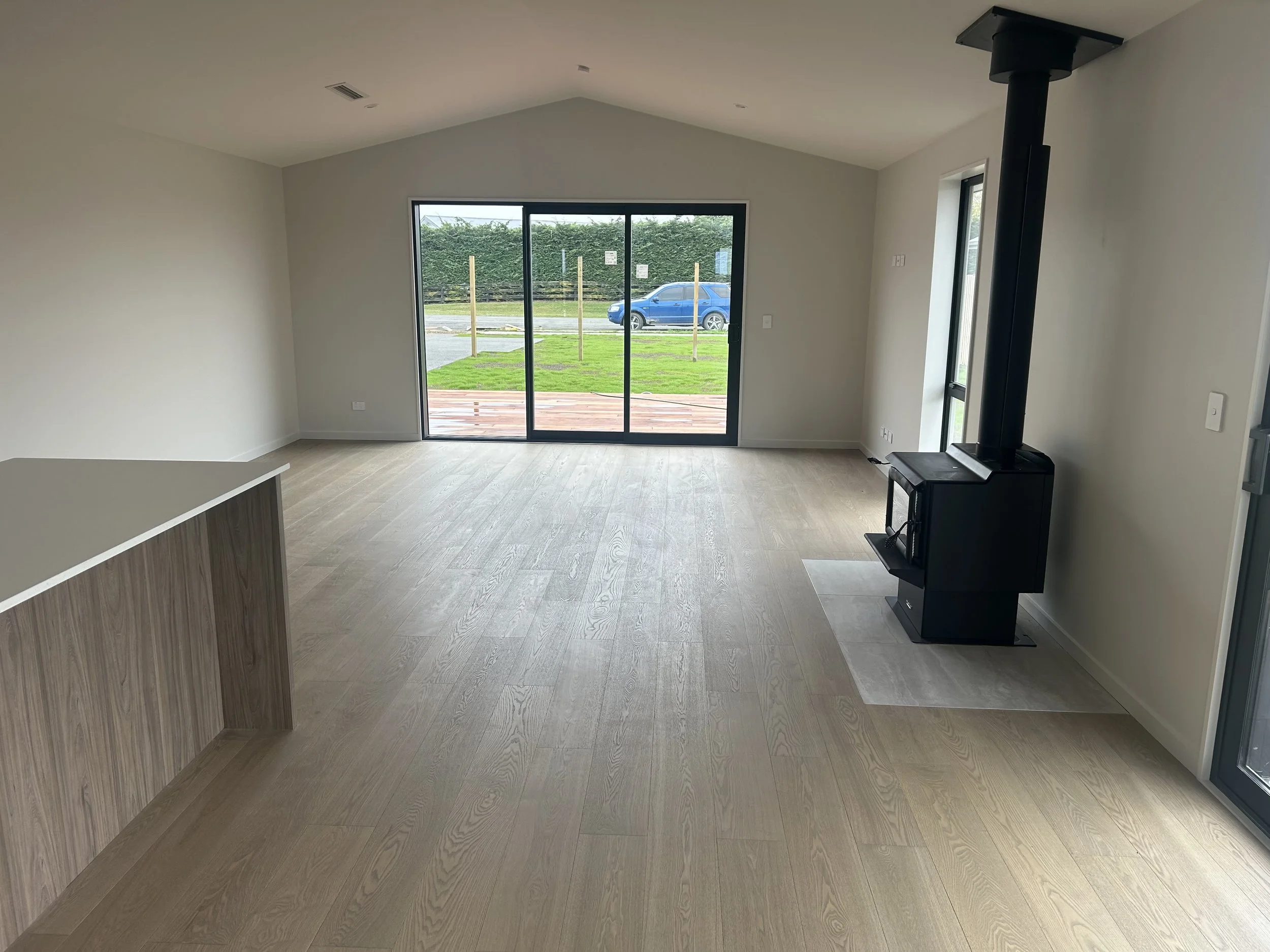 Dusky Ash in living space with fire and kitchen cabinetry