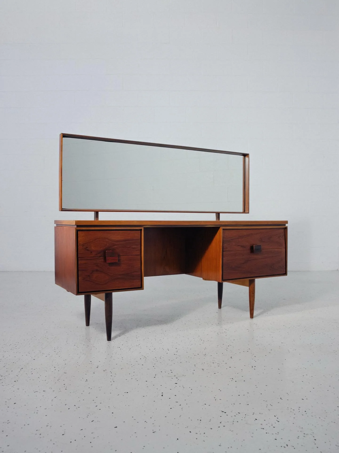 Now available: A highly sought-after mid century dresser complete with original mirror. Crafted in the 1960s by G-PLAN, UK. Designed by the great Ib Kofod-Larsen. This rare beauty features fiery teak grain and rich colors throughout 🔥

This piece wi