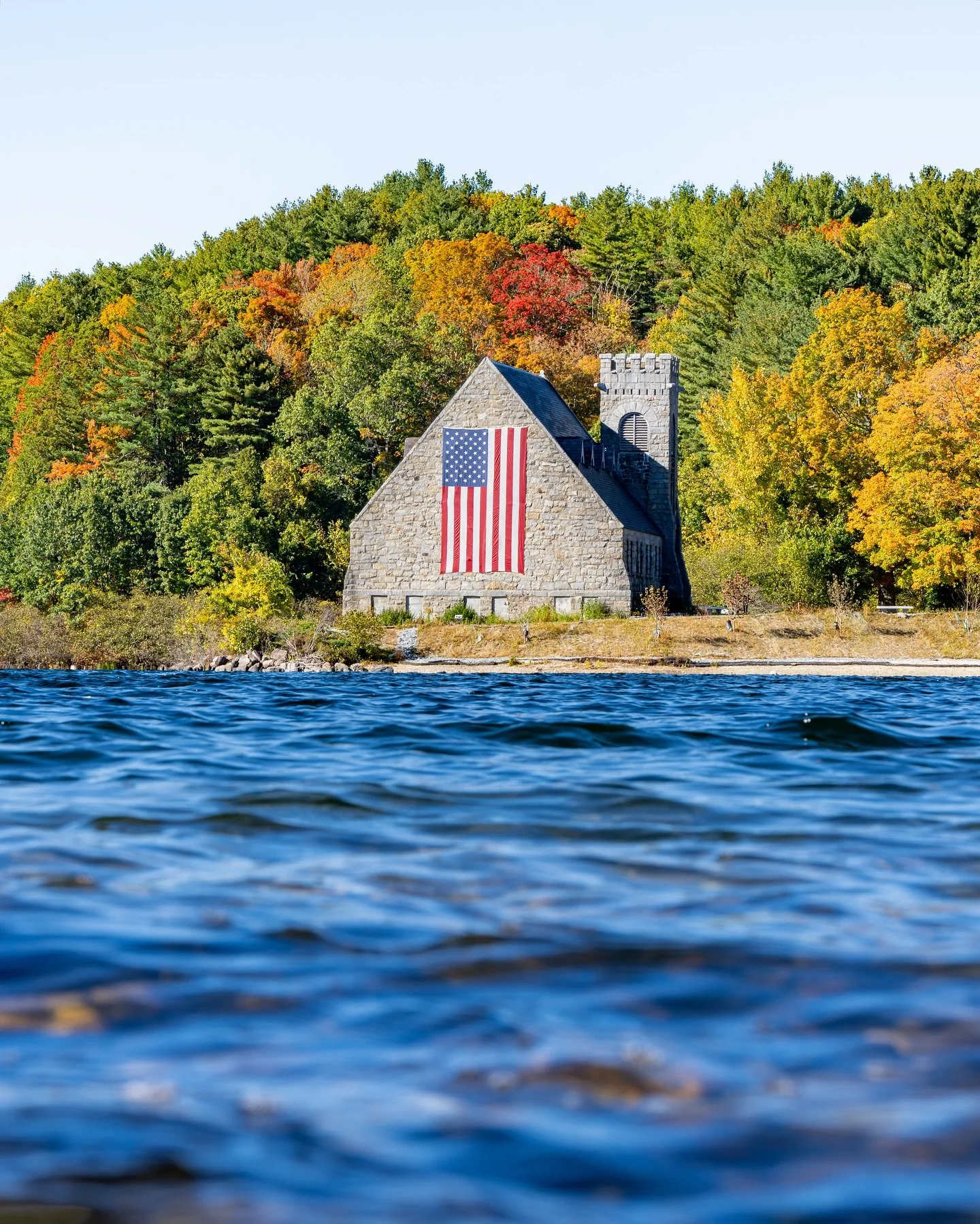 Some views remind you why fall in New England hits different 🇺🇸🍂

The water was calm but alive, the kind that mirrors the changing season perfectly. The stone chapel across the reservoir stood proud, wrapped in fall color and draped in the America