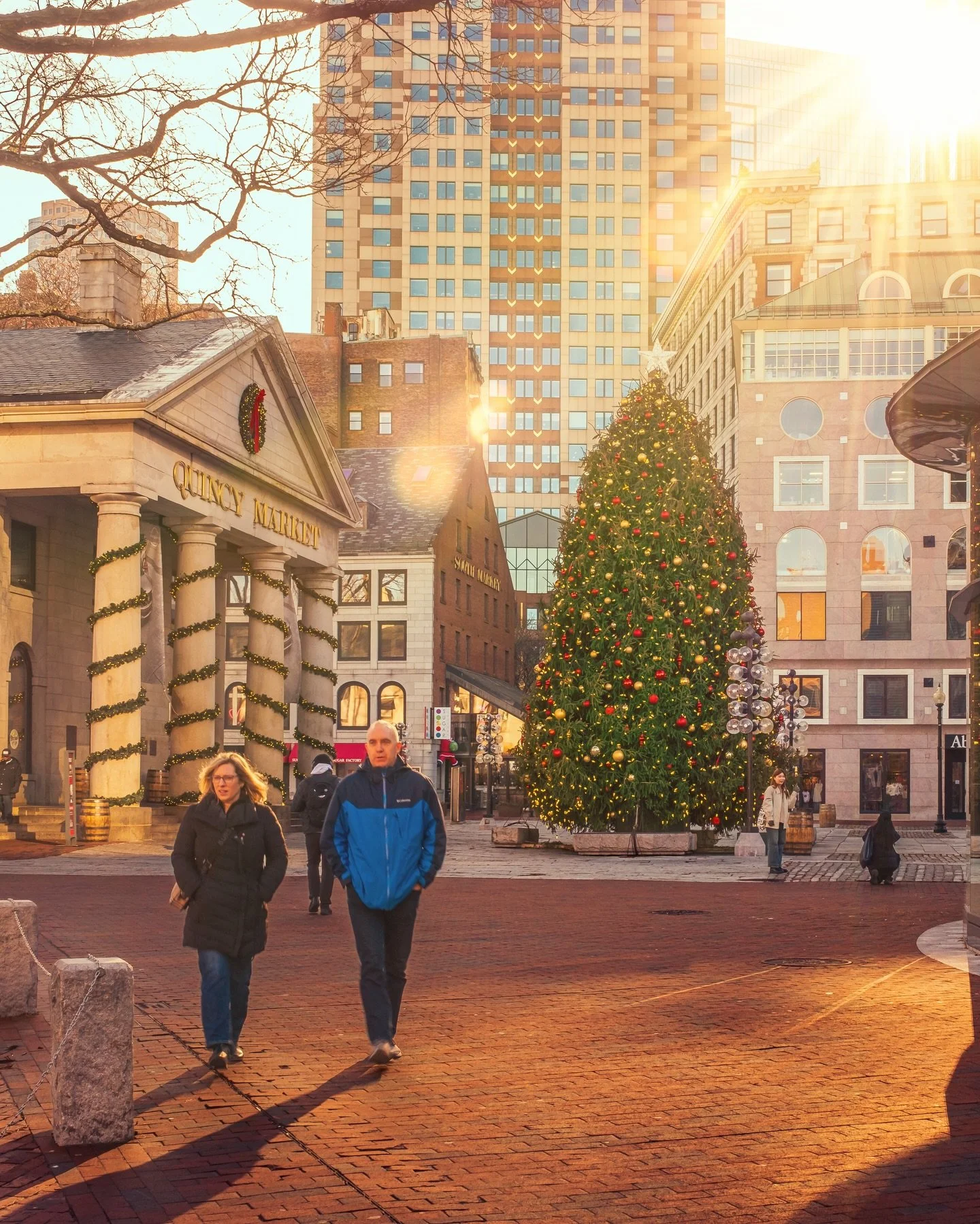 Golden light finds its way into Boston, even on the coldest mornings

Quincy Market in December has a quiet rhythm to it. Brick paths warming under the first light, wreaths still hanging, a Christmas tree standing tall as the city slowly wakes up. In