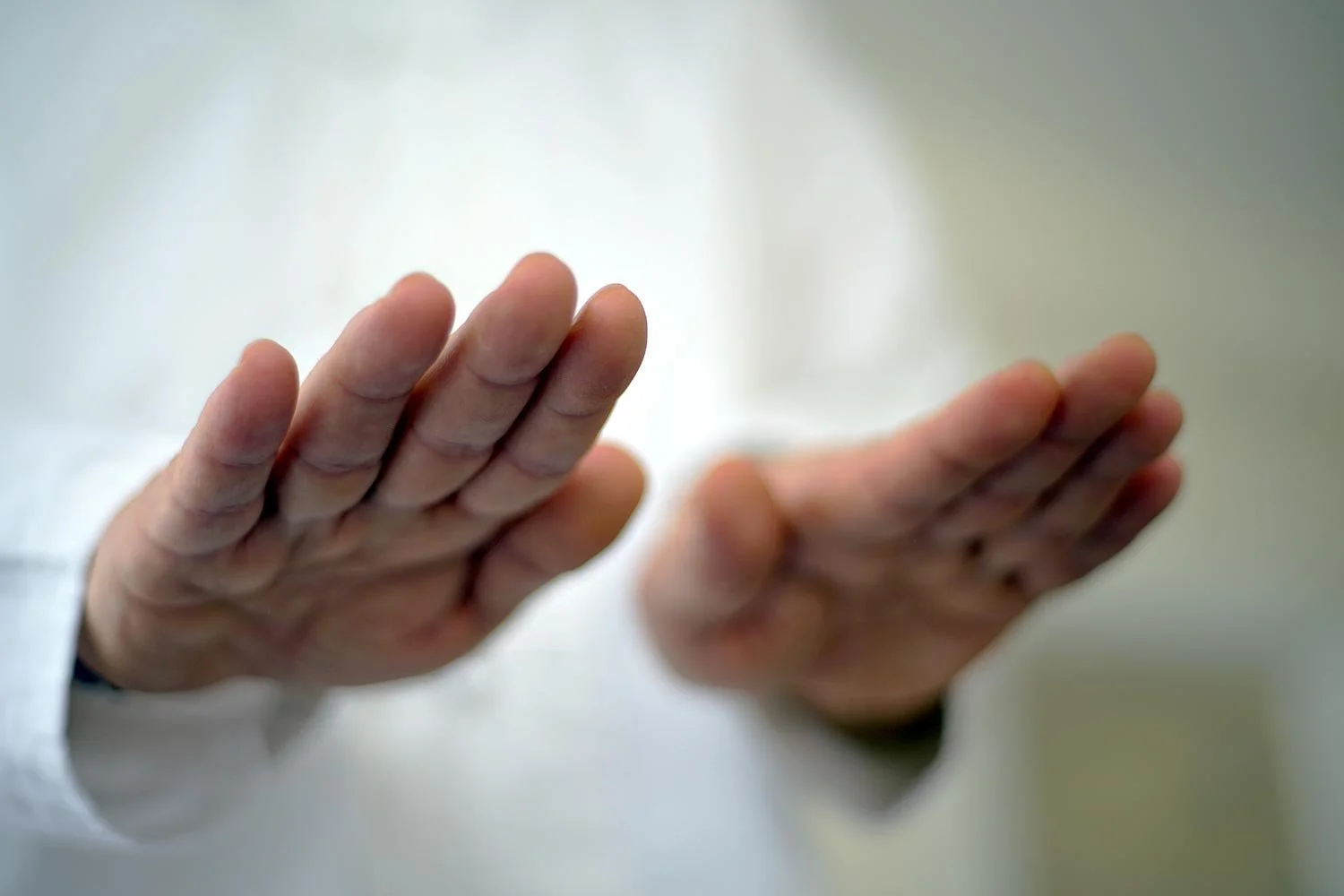 Close-up of a person's hands in a prayer position, fingers together and palms facing each other.