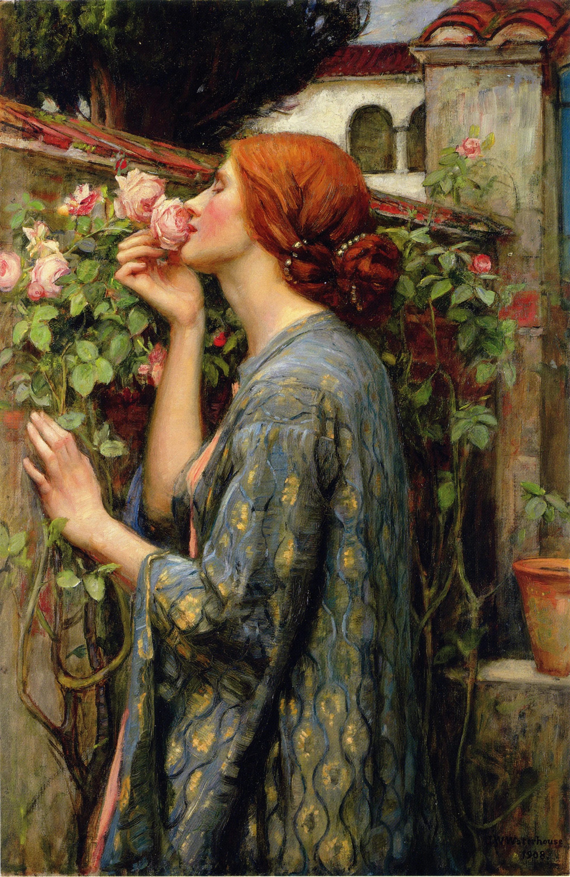 A Pre-Raphaelite painting of a red-haired woman in a blue and gold patterned robe leaning against a stone wall to smell a pink rose in a garden.