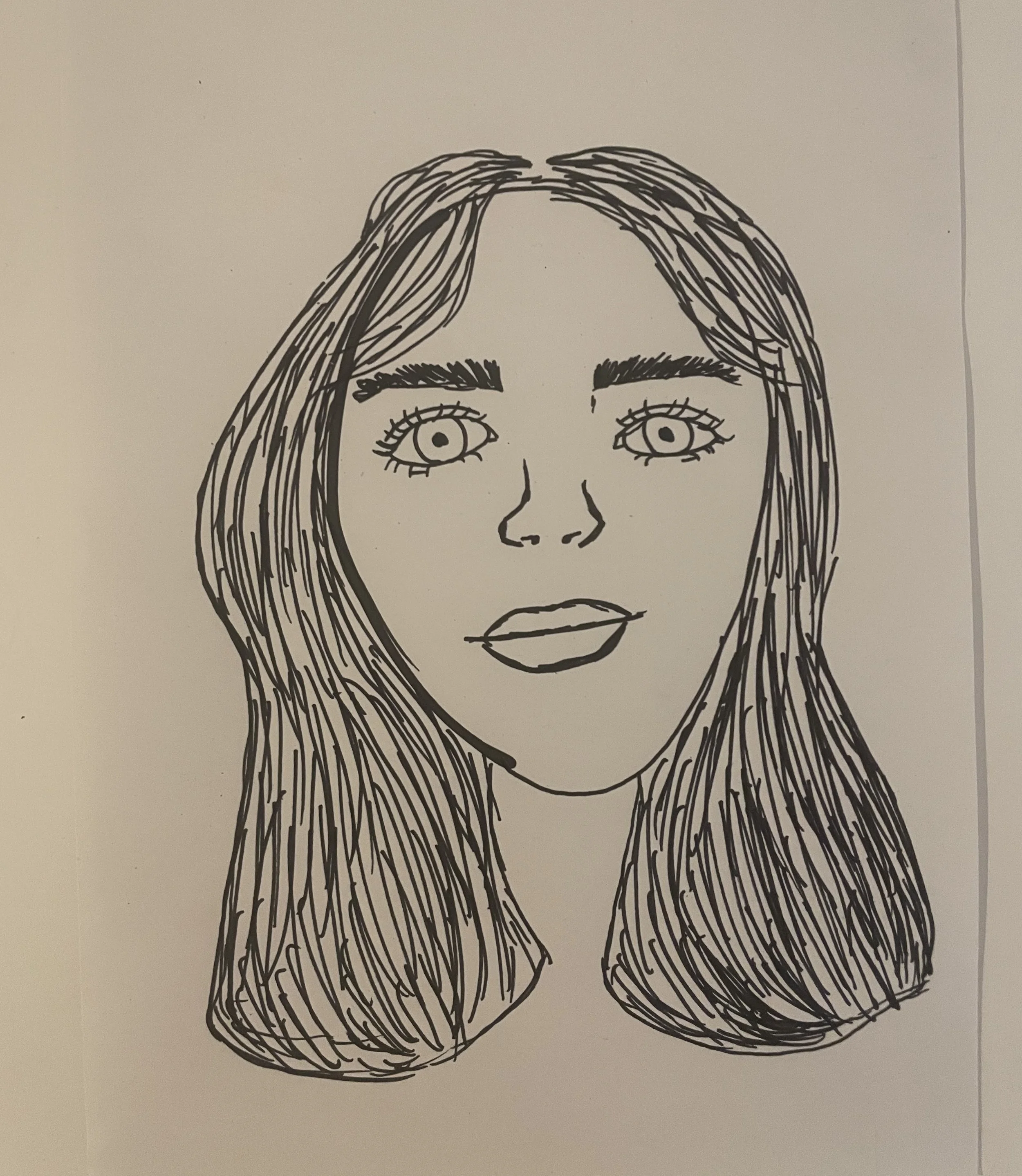 A face, slightly smiling, with shoulder length straight hair.