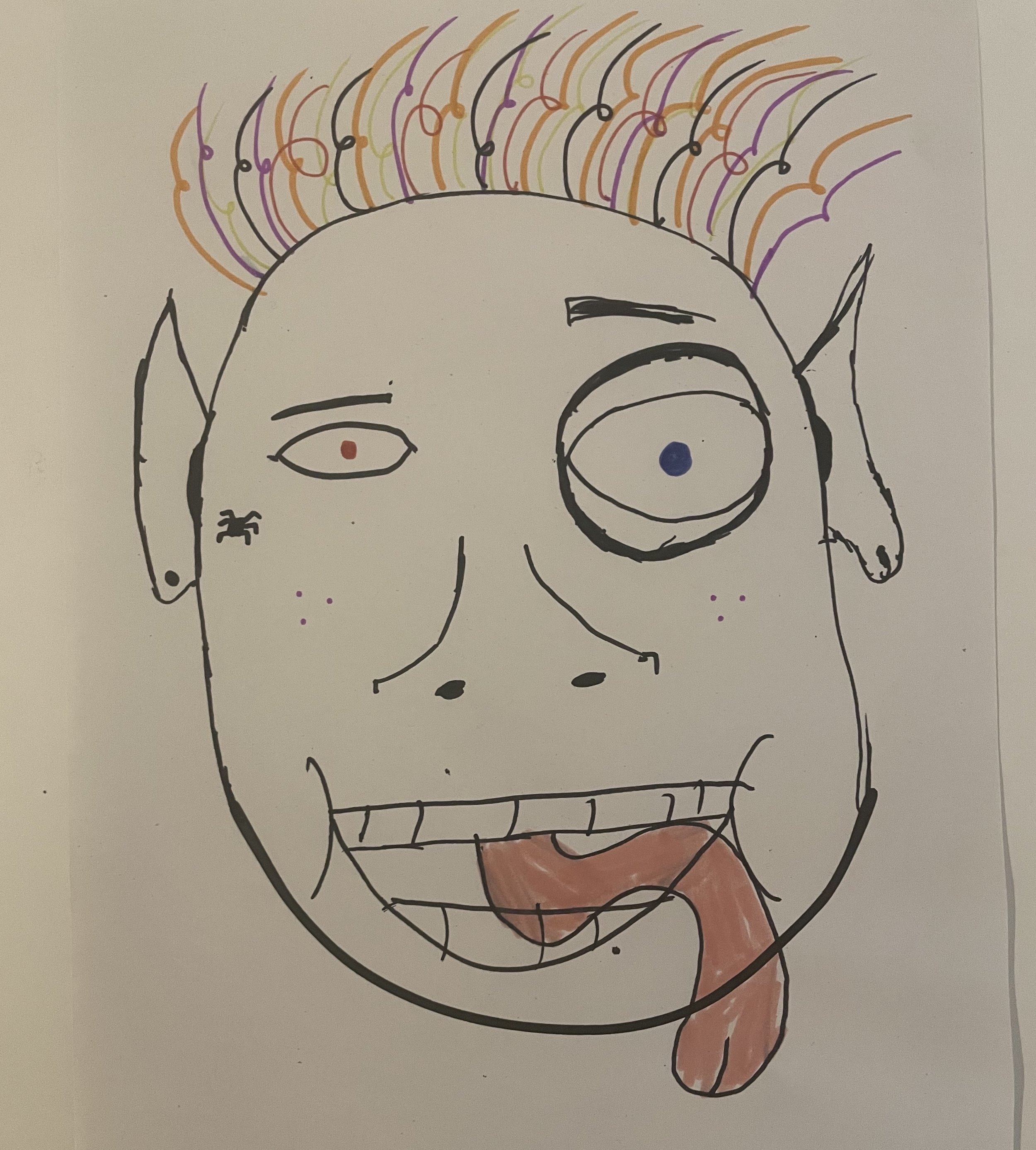 A face with multi-coloured hair, a long pink tongue and eyes different sizes..