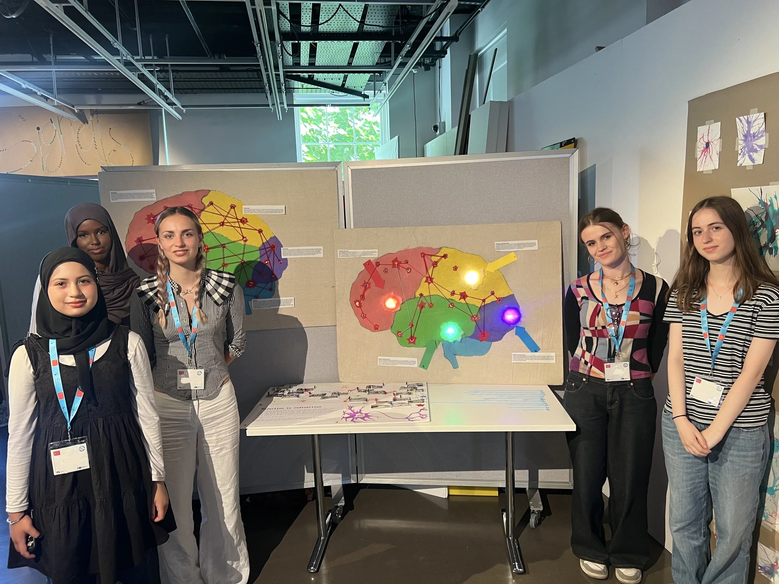 The Rejection is Redirection team around their project, smiling at the camera.