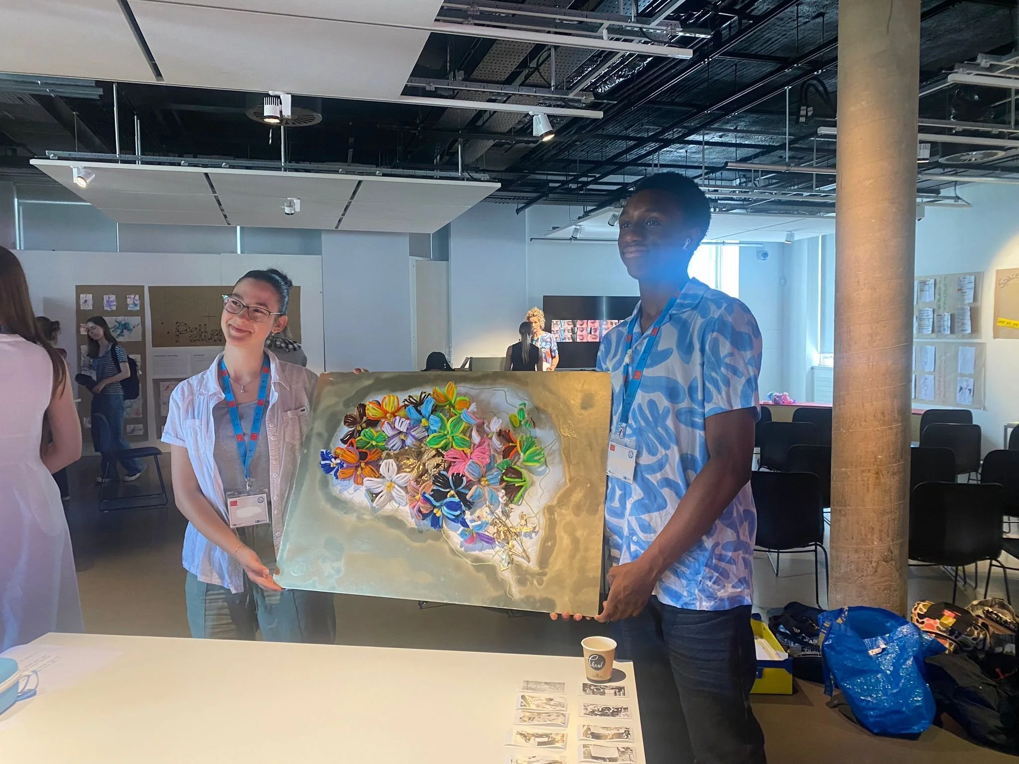 Two members of The Brain in Bloom team hold up their project artwork.