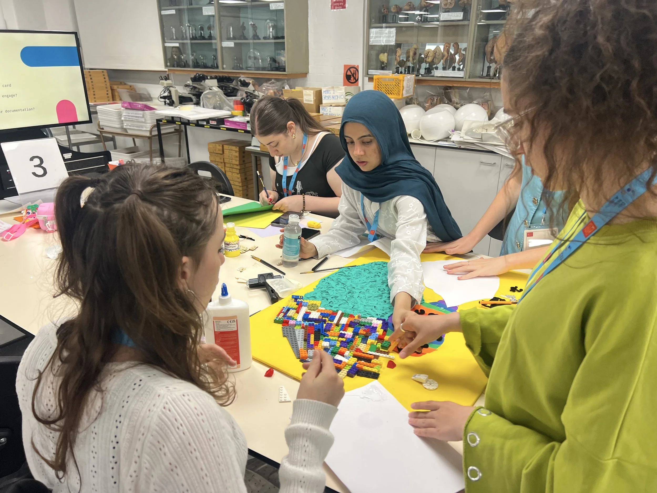 A group of DNA participants build part of their project out of lego.