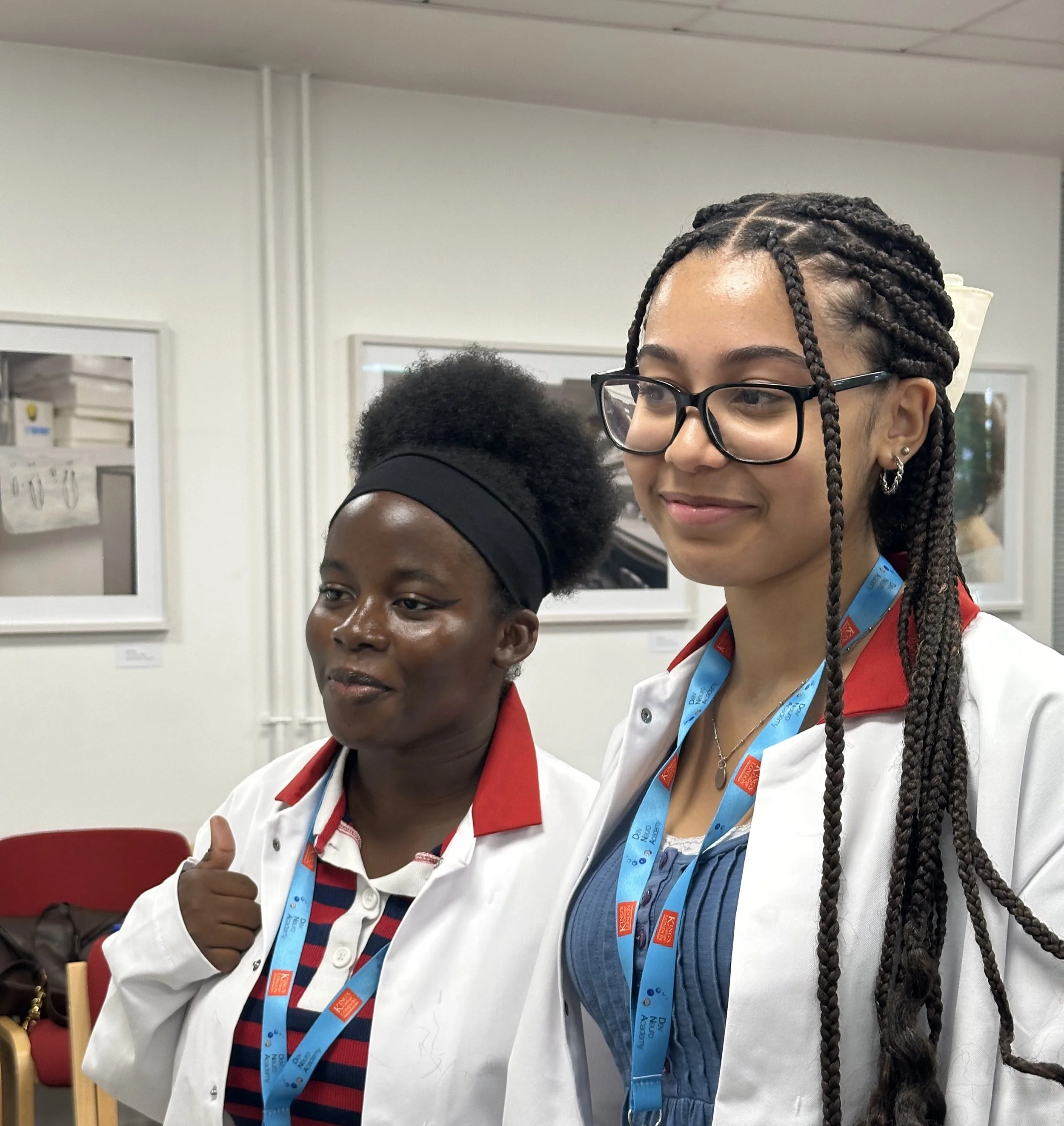 Two participants smile in lab coats.