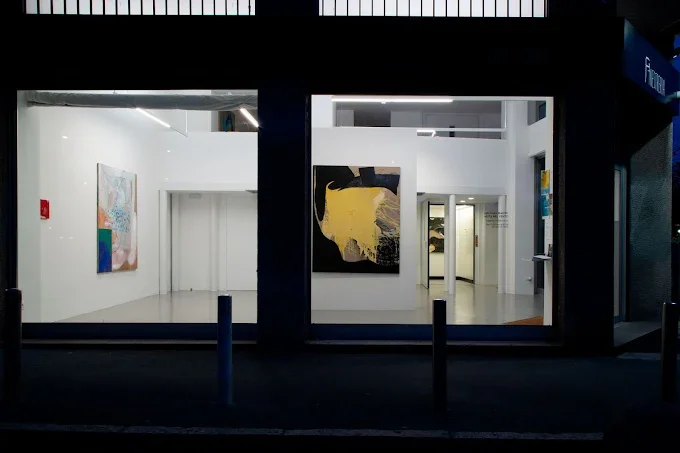Interno di una galleria d'arte con dipinti esposti alle pareti