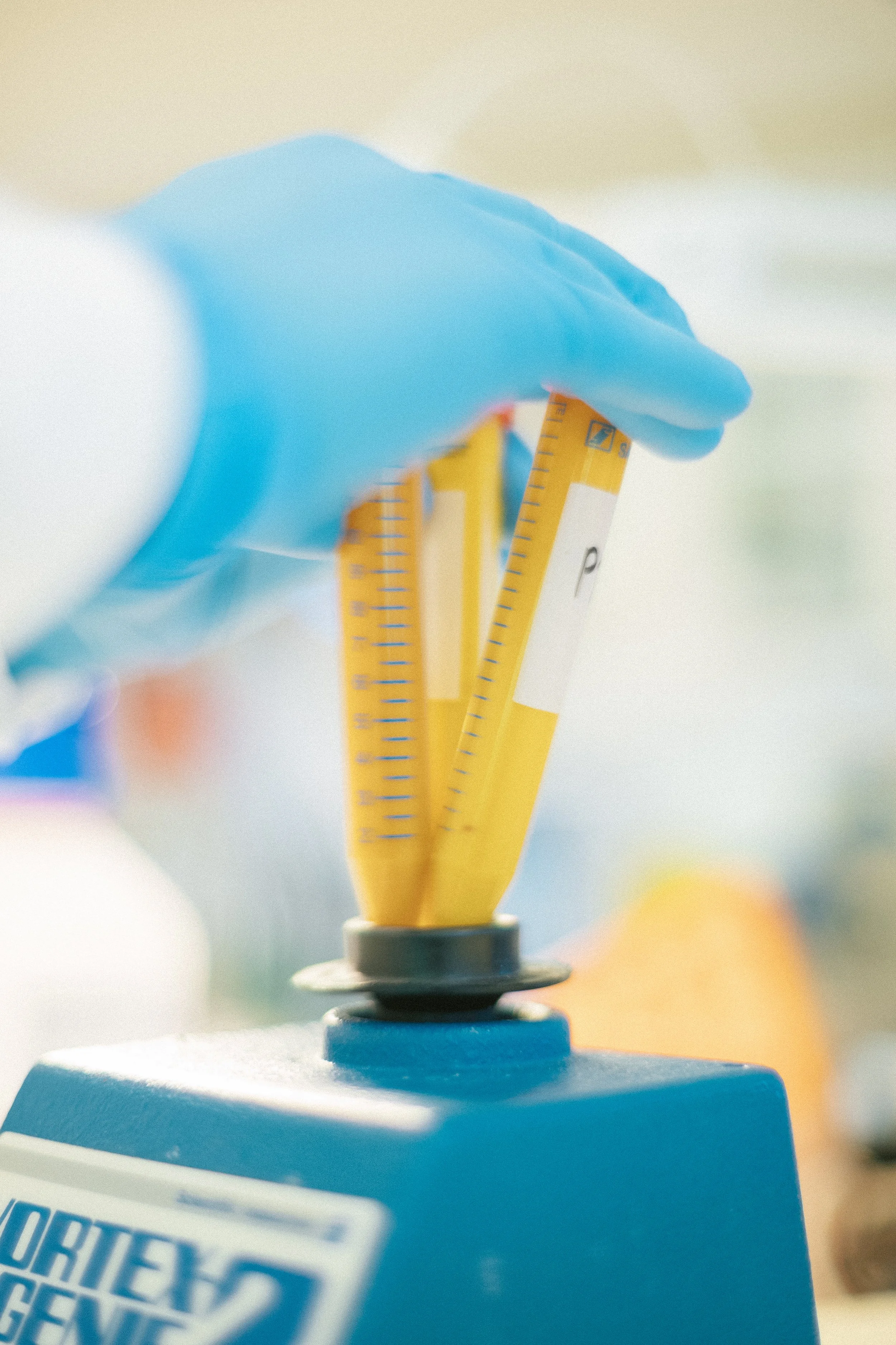 Zoomed picture of a researcher in a lab using a vortex mixer for eDNA sampling.