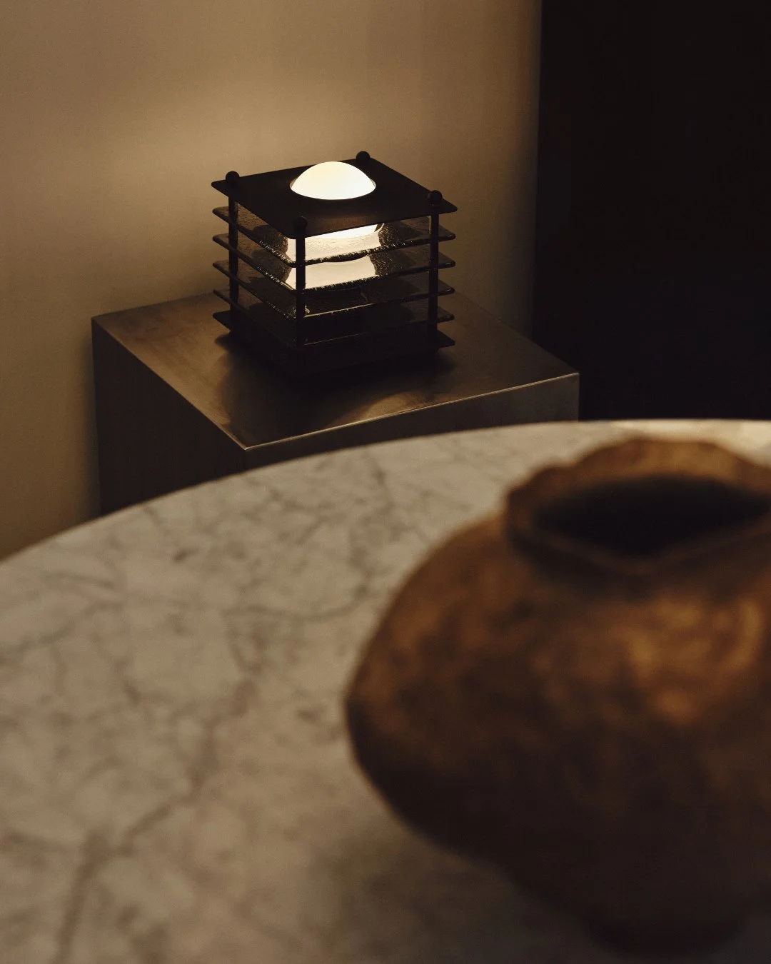 Materials shape both presence and atmosphere.⁠
⁠
Layers of smoked glass introduce depth and quiet complexity, their tinted surfaces catching and filtering light as it passes through. Each plate subtly refracts illumination, creating a softer glow and