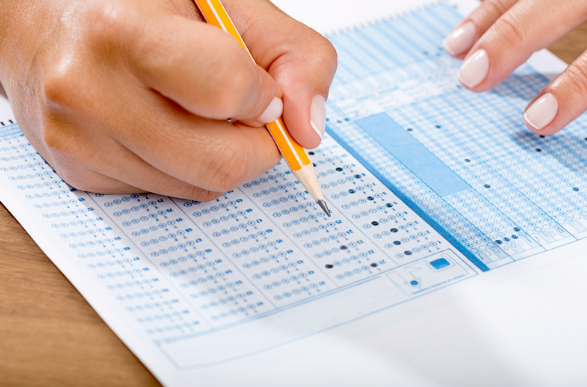 A stack of calendars next to a pencil, laying on top of a blue background.