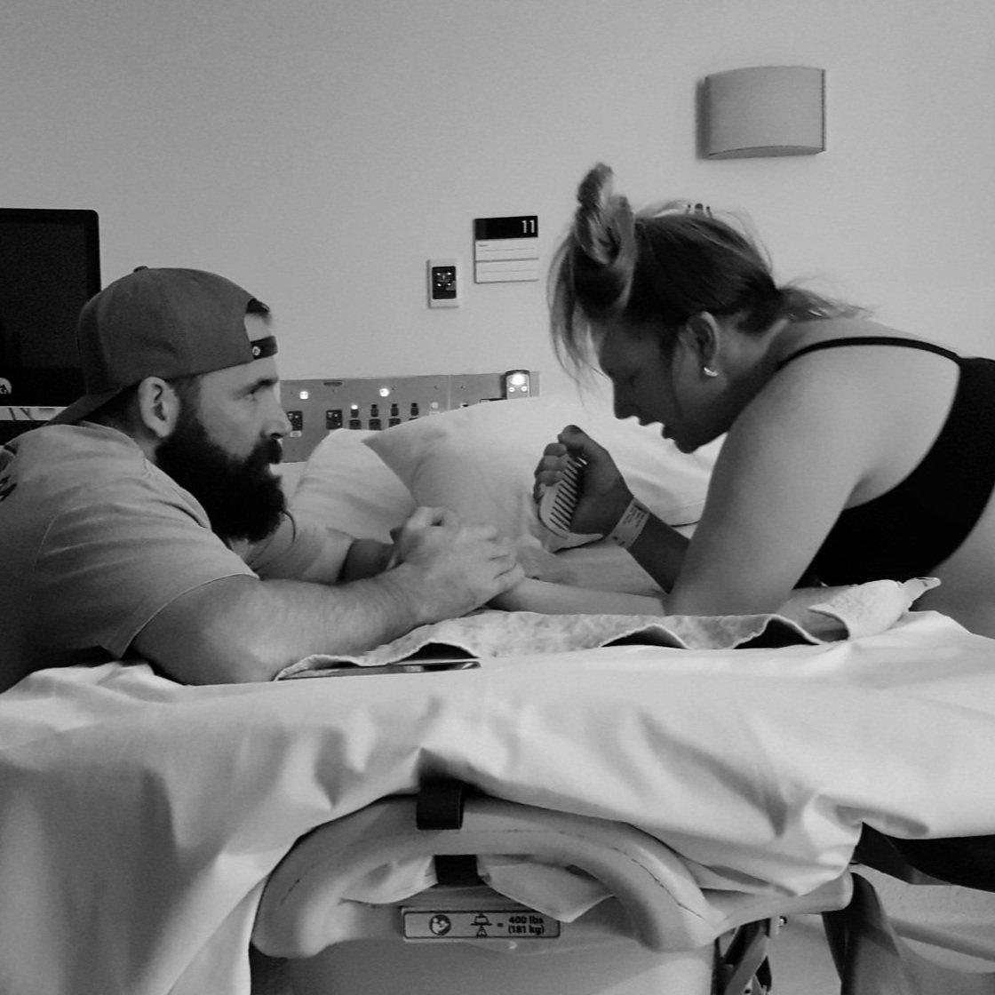 Husband supporting wife in labour, using a birth comb