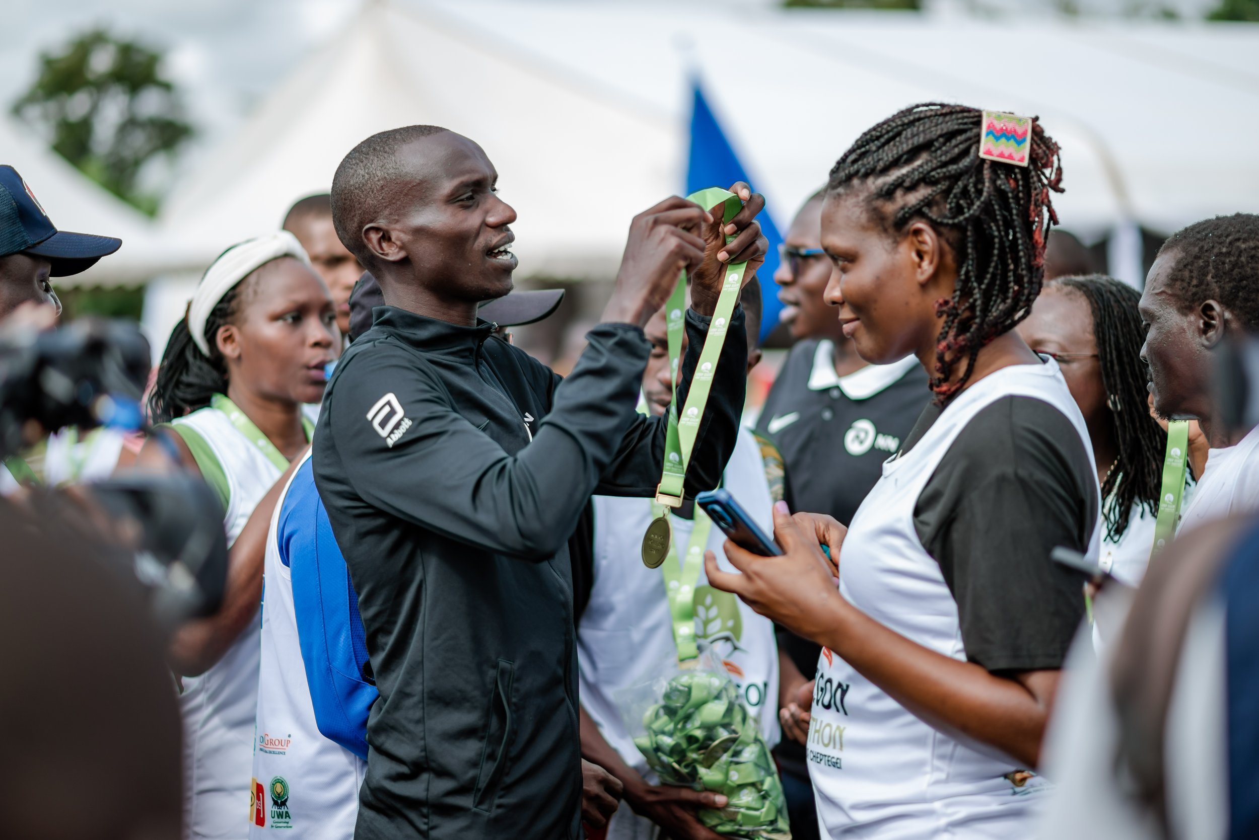 Joshua Cheptegei presents medals to participants during the UNDP Elgon Half Marathon, an initiative elevating tourism in Uganda's Elgon region..jpg