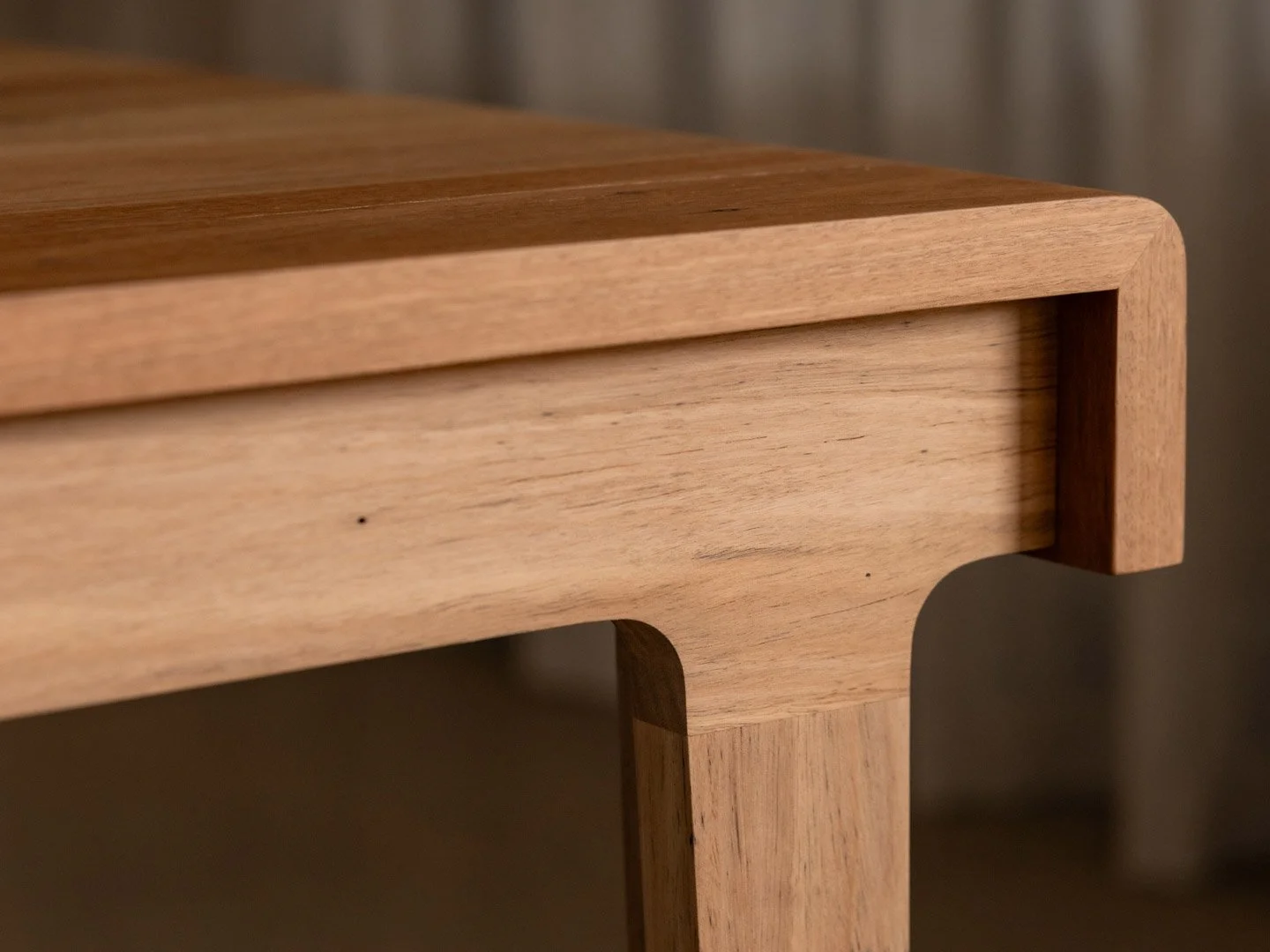 Close-up of a wooden table corner showing the natural grain and smooth finish.