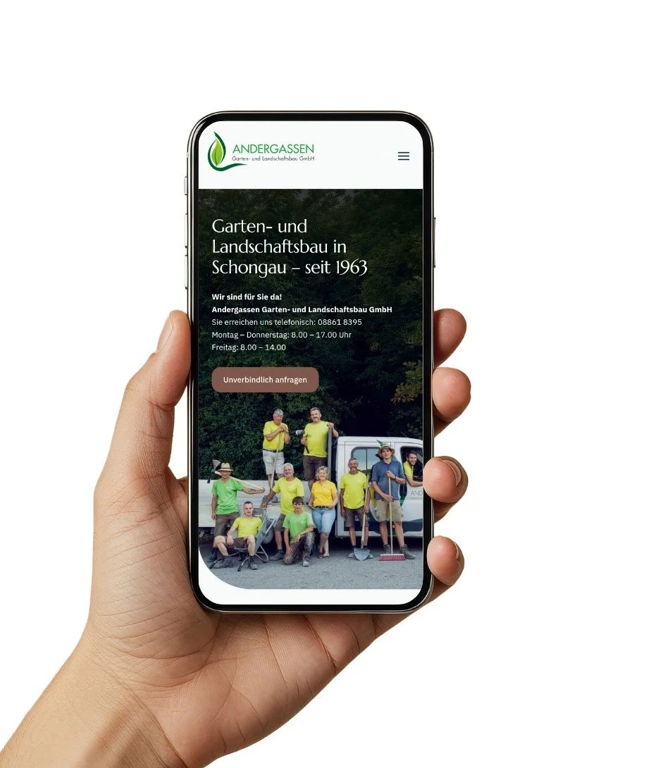 Ein Hand hält ein Smartphone, das eine Webseite eines Gartenbaubetriebs namens 'Andergassen' zeigt. Die Webseite enthält Informationen über den Betrieb in Schongau, gegründet 1963, mit Kontaktdaten und Öffnungszeiten sowie einem Gruppenfoto der Mitar