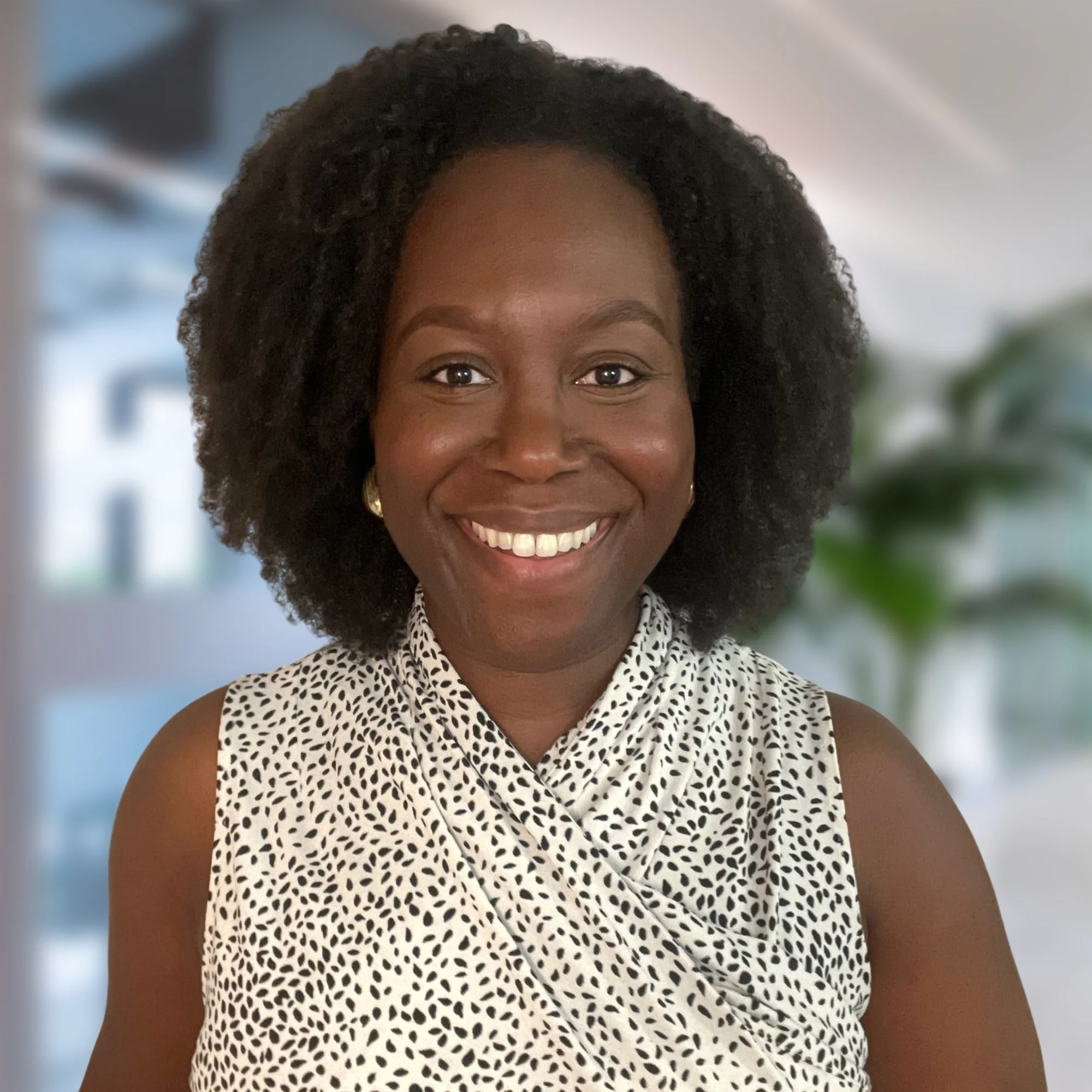 A burnout expert smiling with an office or modern indoor background.