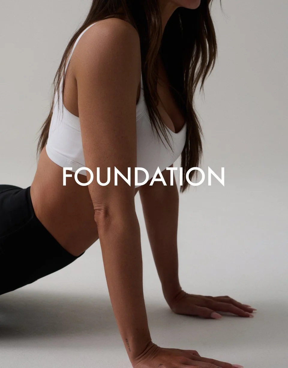 Person in a yoga pose wearing a white sports bra and black leggings with the word 'FOUNDATION' overlaid.