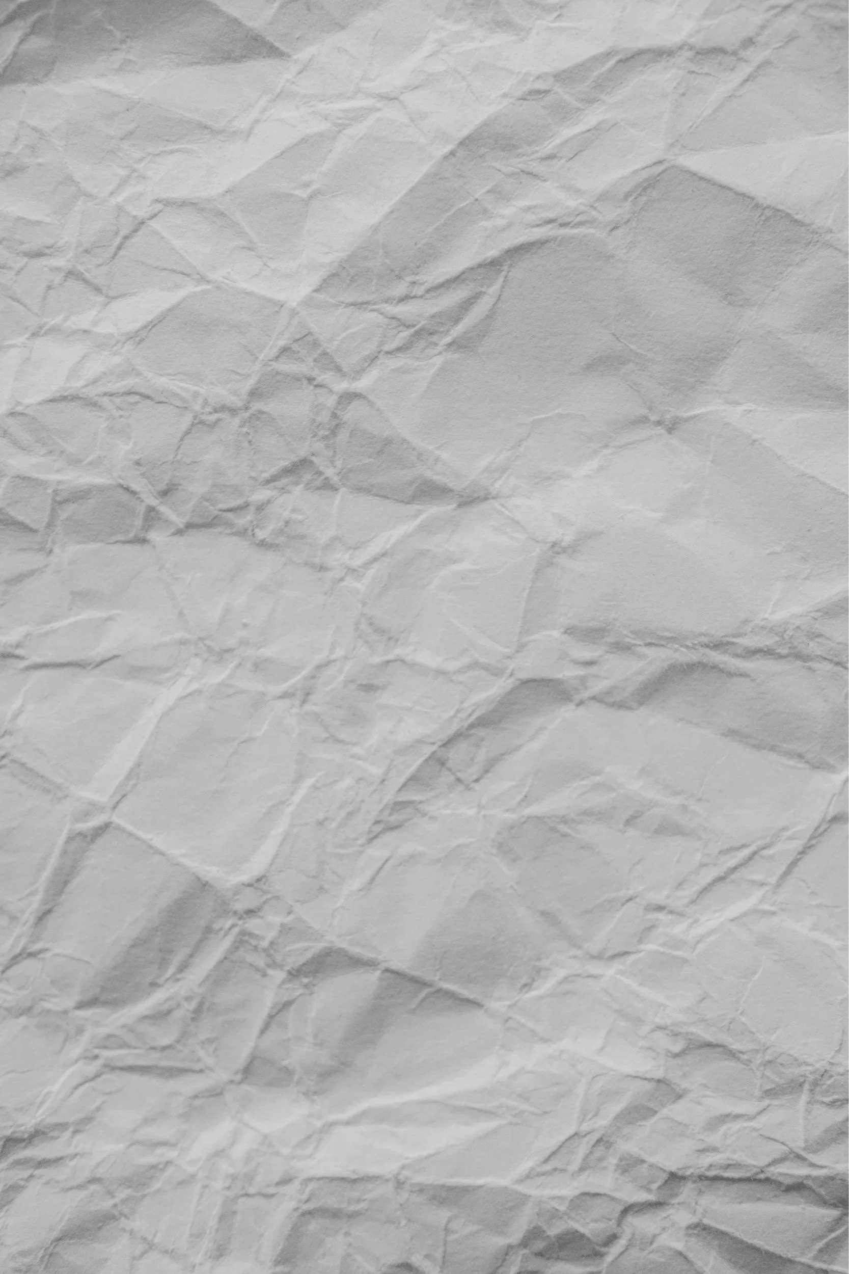 A crumpled piece of white paper with visible creases and shadows.