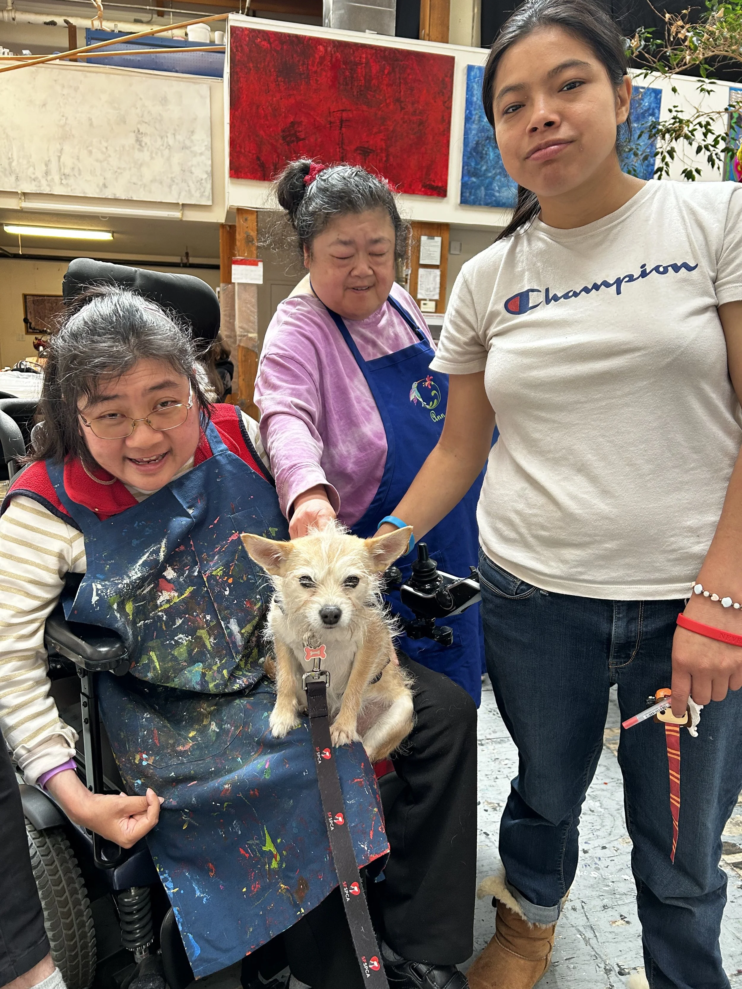 Therapy dog visiting with 3 artists at Creativity Explored
