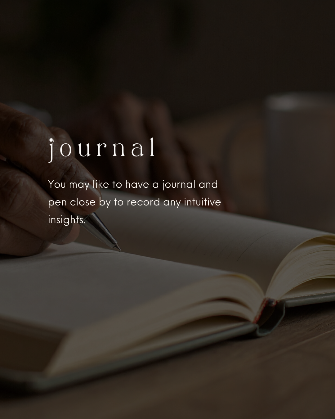 A person writes in a journal with a pen, with a coffee mug in the background.