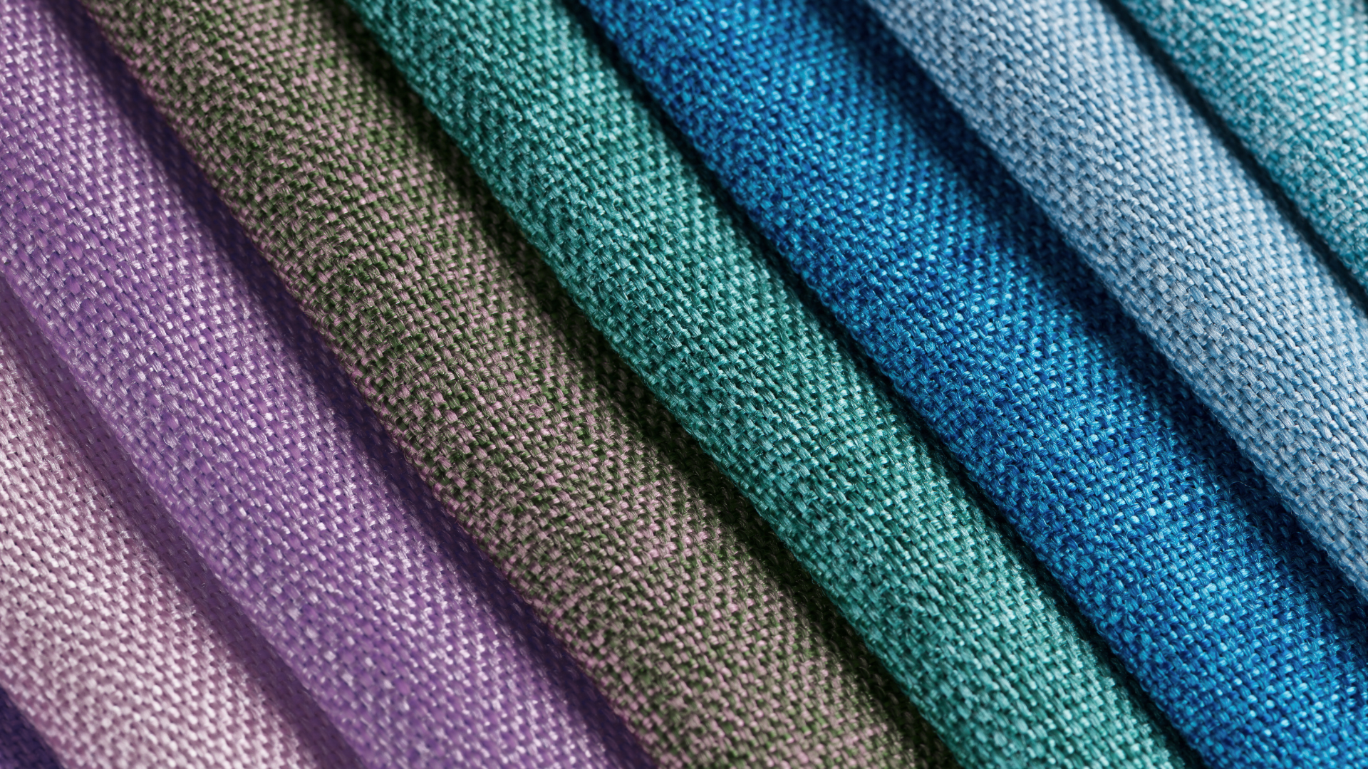 Frotti di tessuto colorato in tonalità di viola, verde, blu e azzurro, piegati in modo casuale