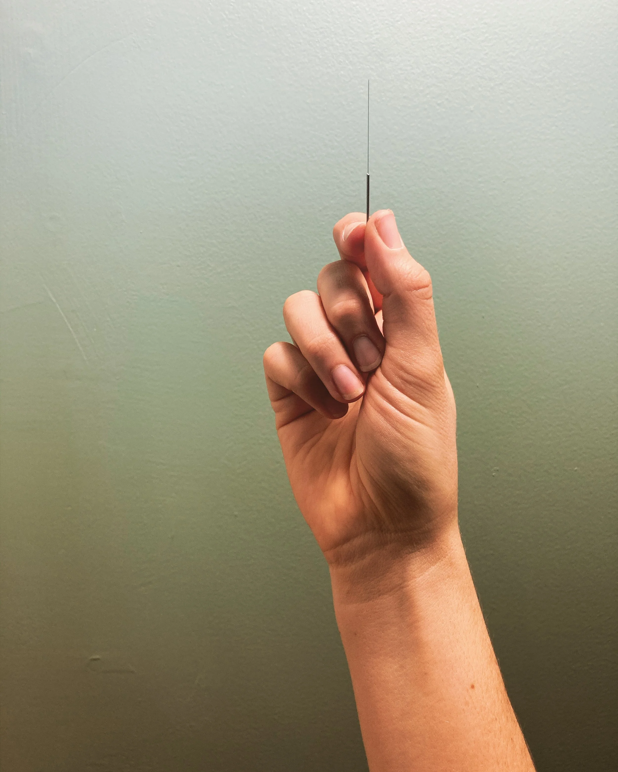 Hand holding acupuncture needle