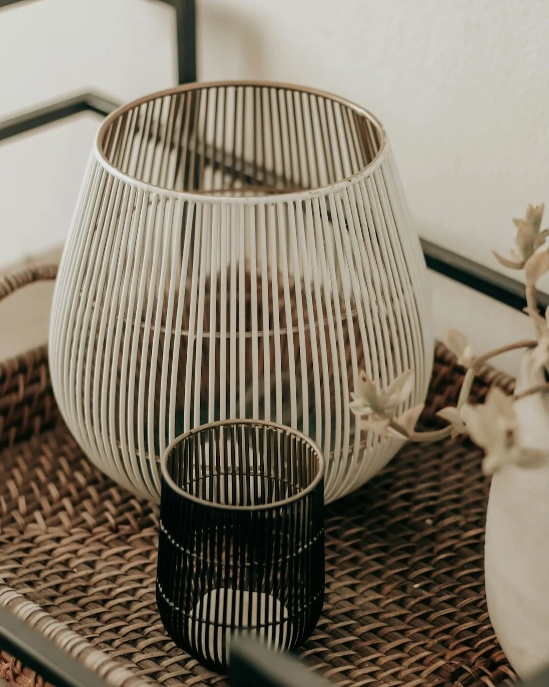 Decorative wooden slat lampshade and small candle holder on woven tray