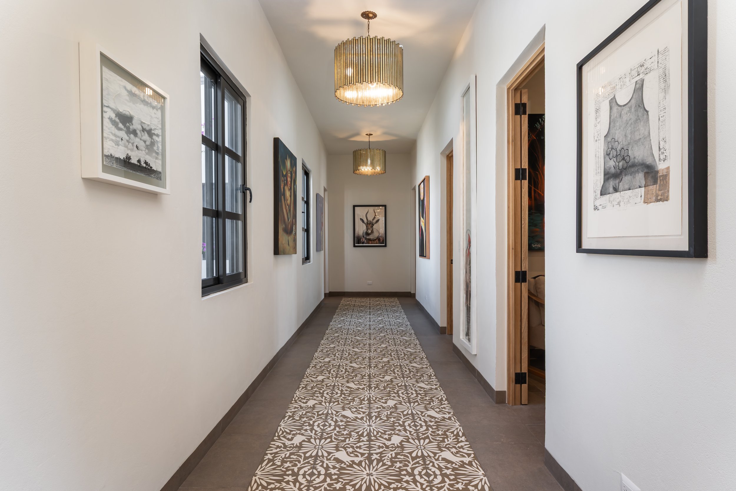 Second-floor hallway/art gallery!  Three bedrooms are on the right, two bedroom are on the left.