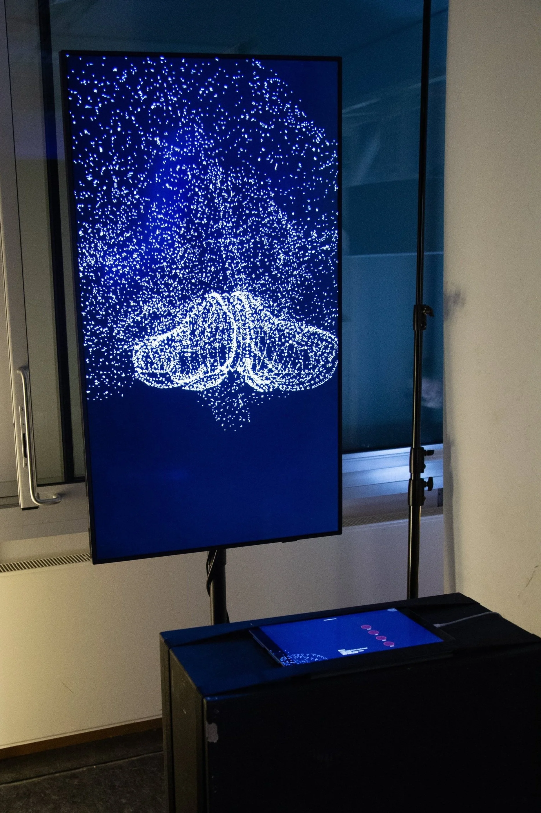 Ein Bildschirm zeigt ein digitales Bild eines leuchtenden Mädchens mit braunen Haaren, das von blauen Lichterlinien umgeben ist.