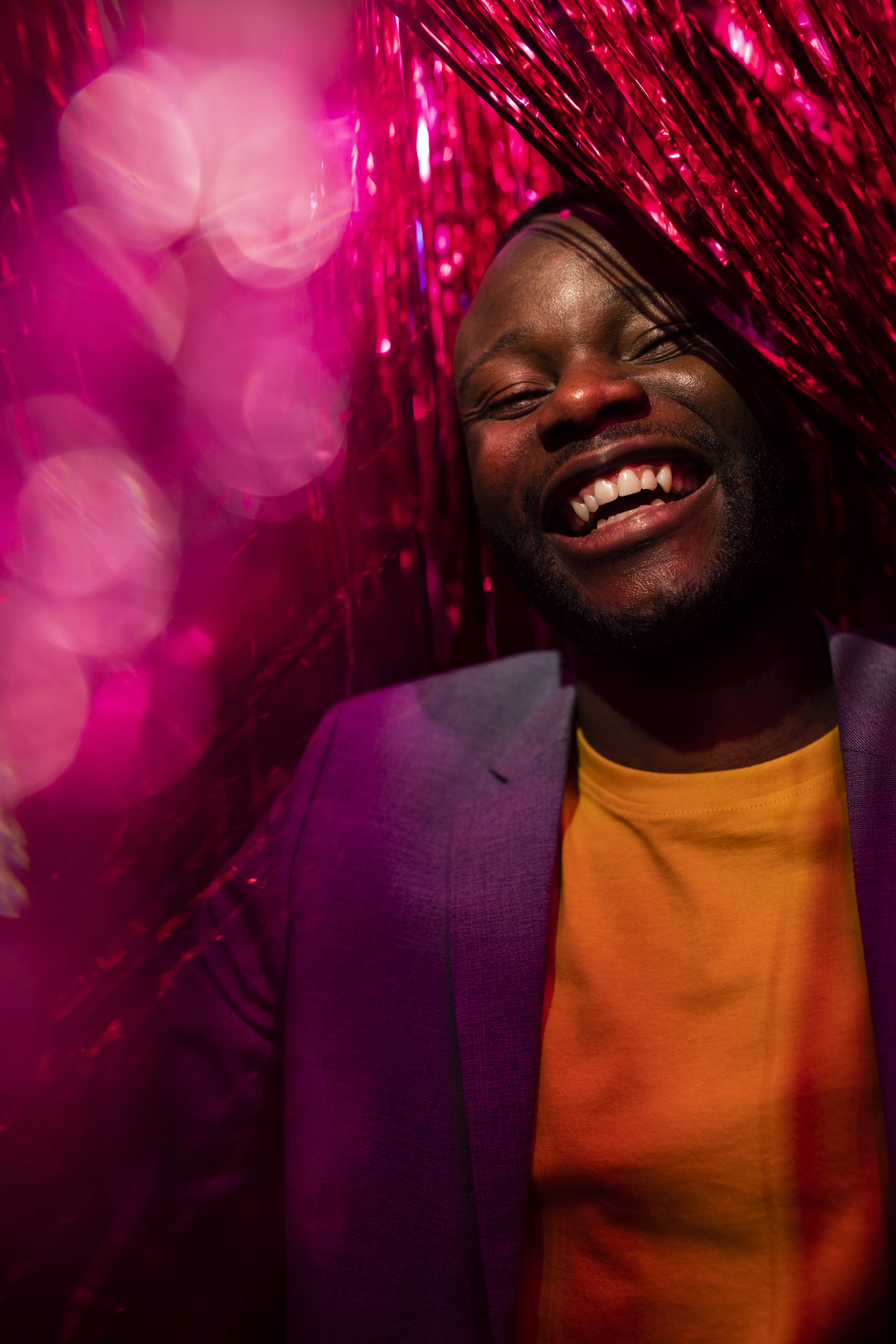 Un hombre negro divirtiéndose en una fiesta con serpentinas de color rojo