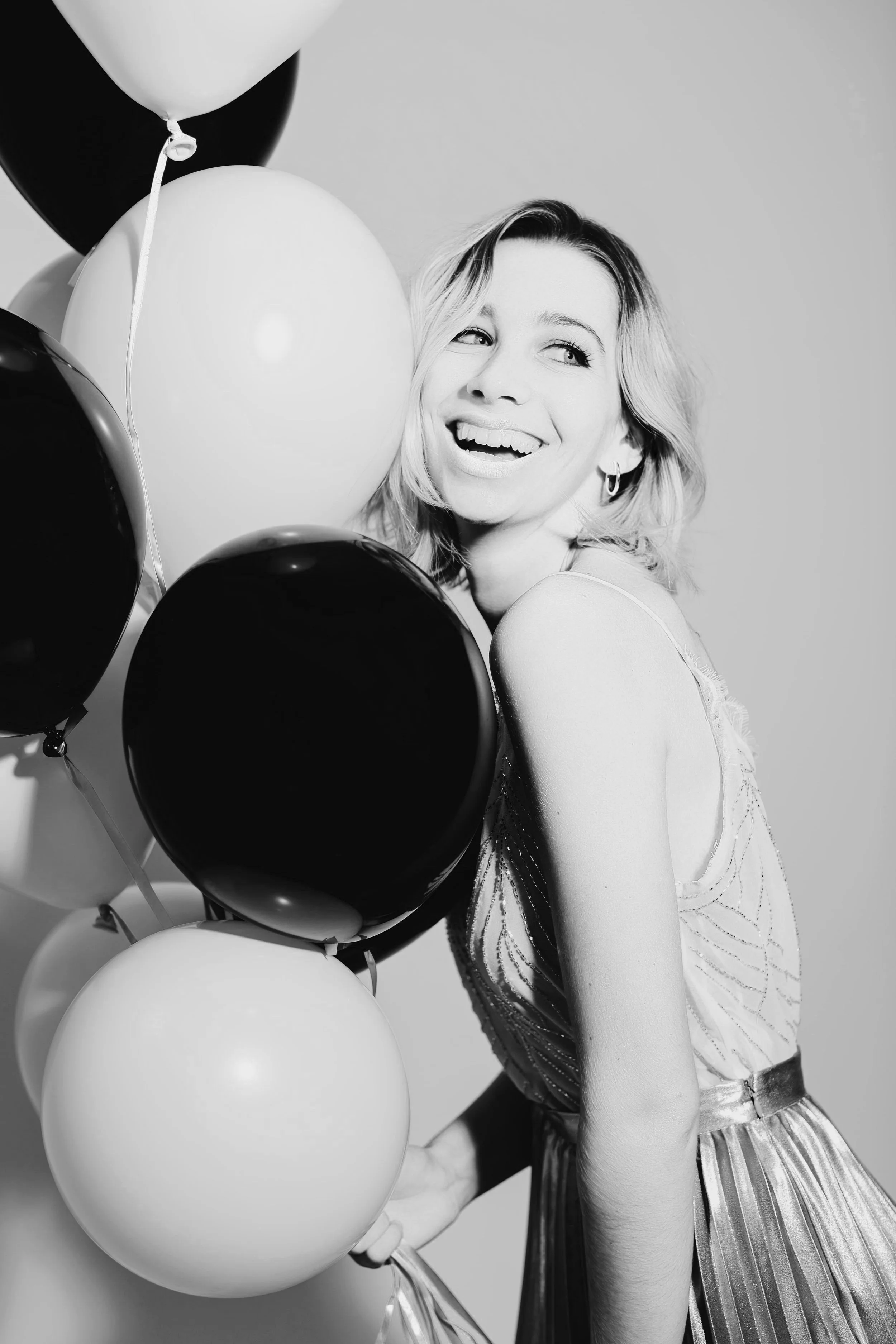 Mujer bella que sonríe y sostiene globos en una celebración de Año Nuevo