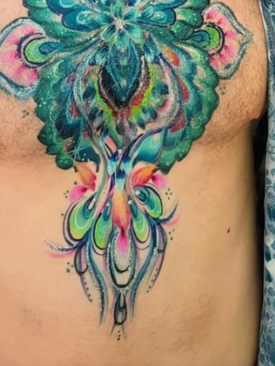 Colorful face paint of a butterfly with abstract patterns on a person's chest.
